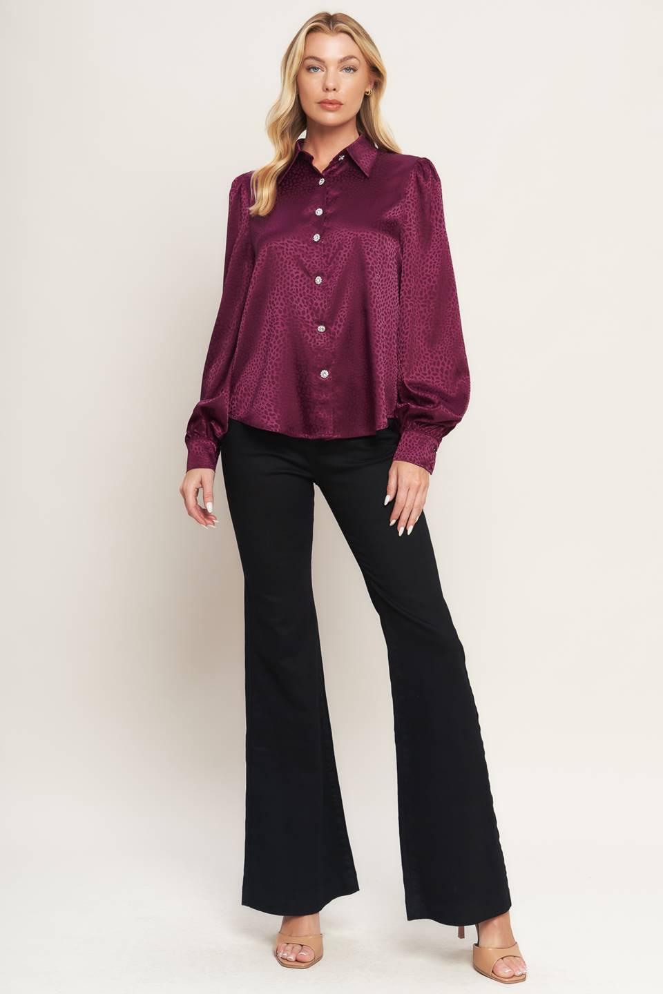 A solid woven top featuring shirt collar, jewel button down, long puff sleeve and cuff