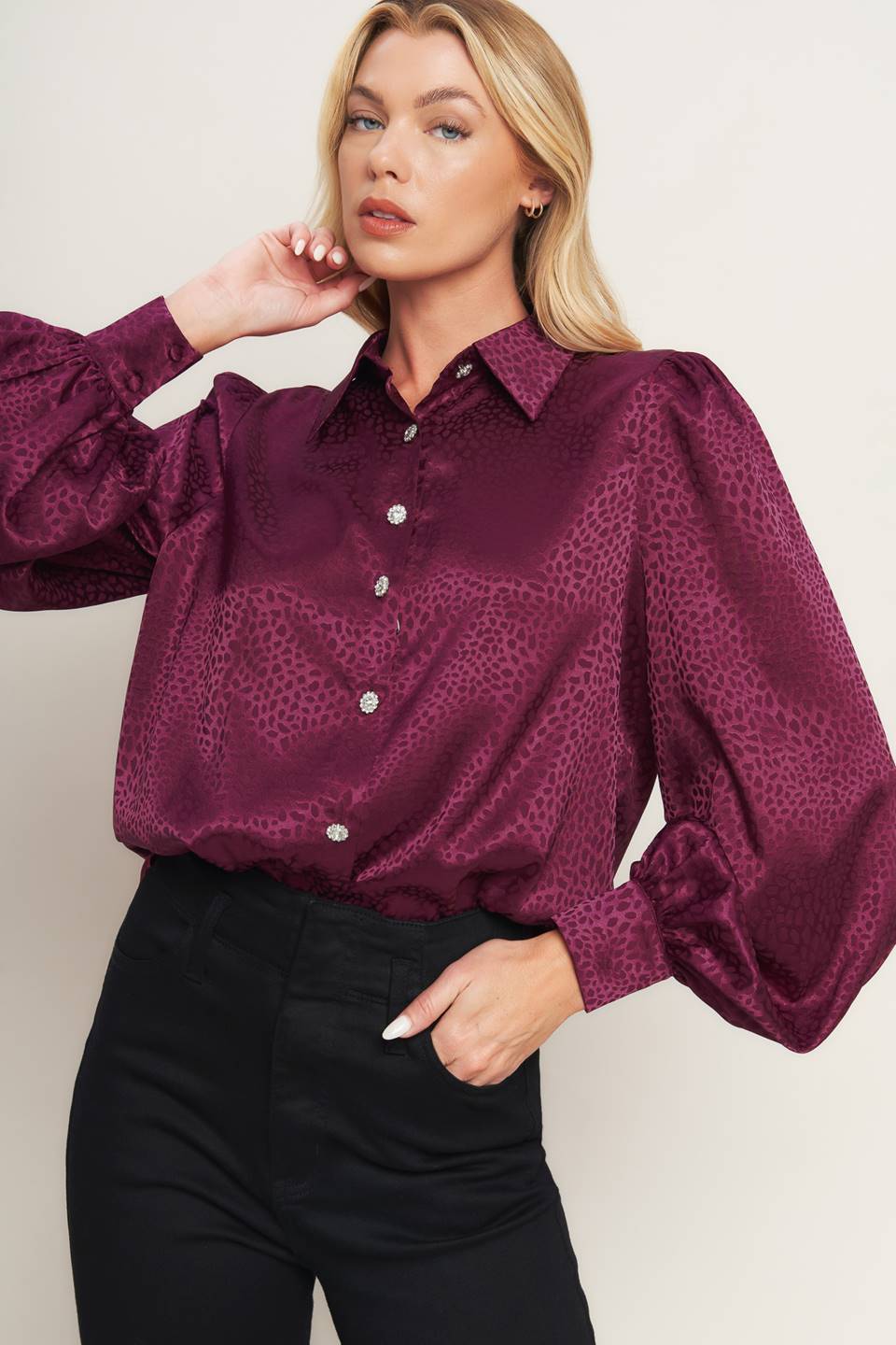A solid woven top featuring shirt collar, jewel button down, long puff sleeve and cuff