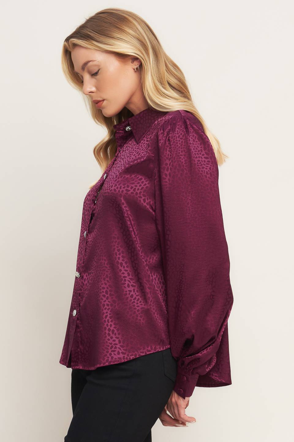 A solid woven top featuring shirt collar, jewel button down, long puff sleeve and cuff