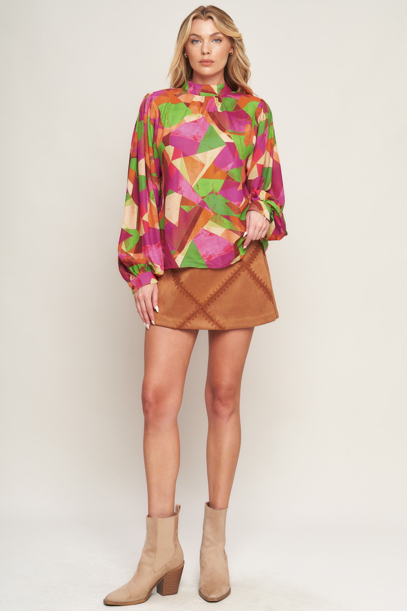 A printed woven top featuring high neckline, wide long sleeve with cuff and back neck button closure