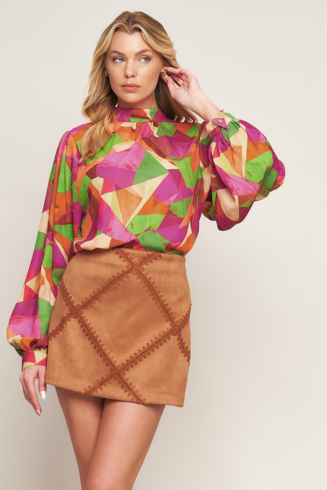 A printed woven top featuring high neckline, wide long sleeve with cuff and back neck button closure