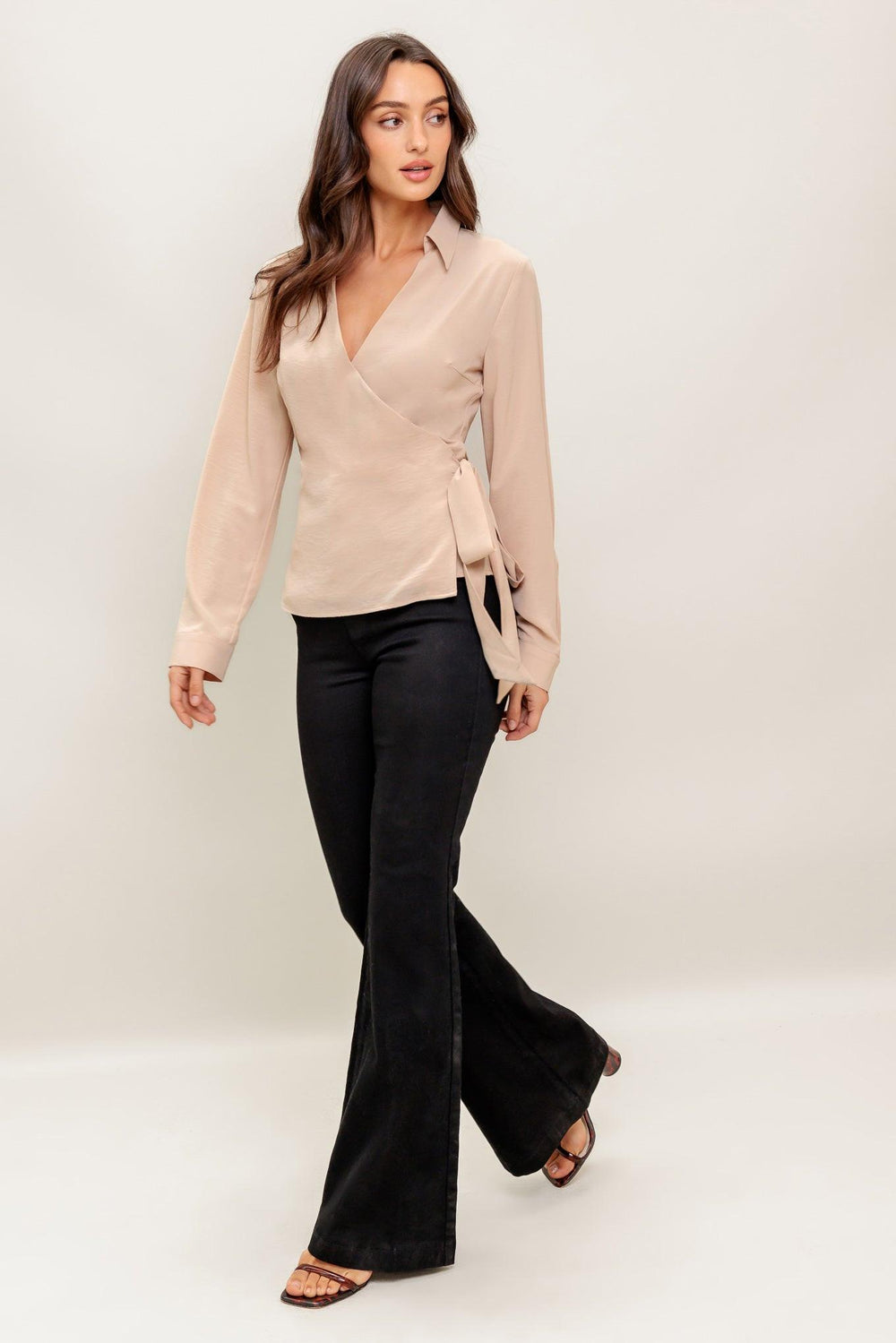 A solid woven top featuring collar, surplice neckline, long sleeve and true wrap