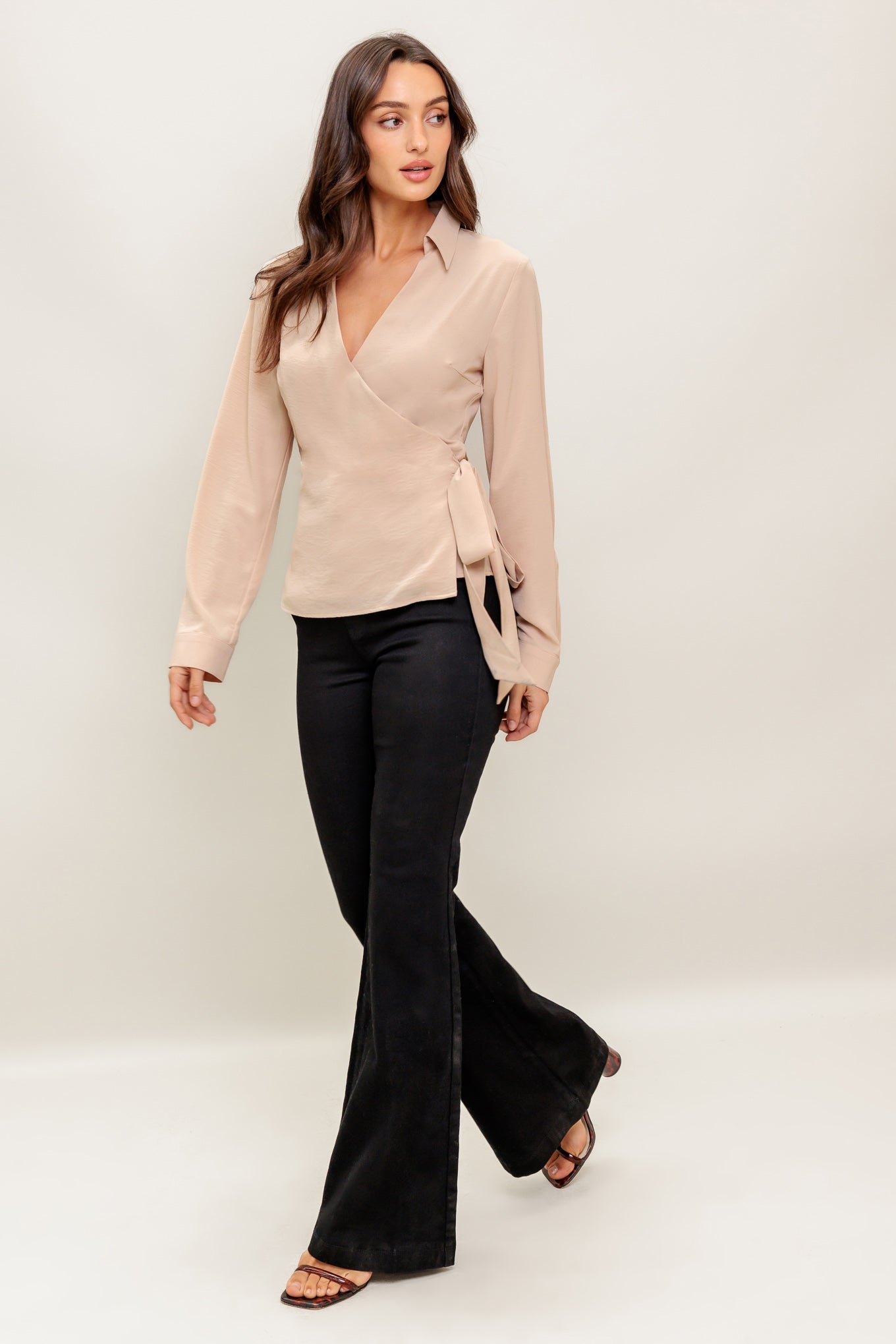 A solid woven top featuring collar, surplice neckline, long sleeve and true wrap