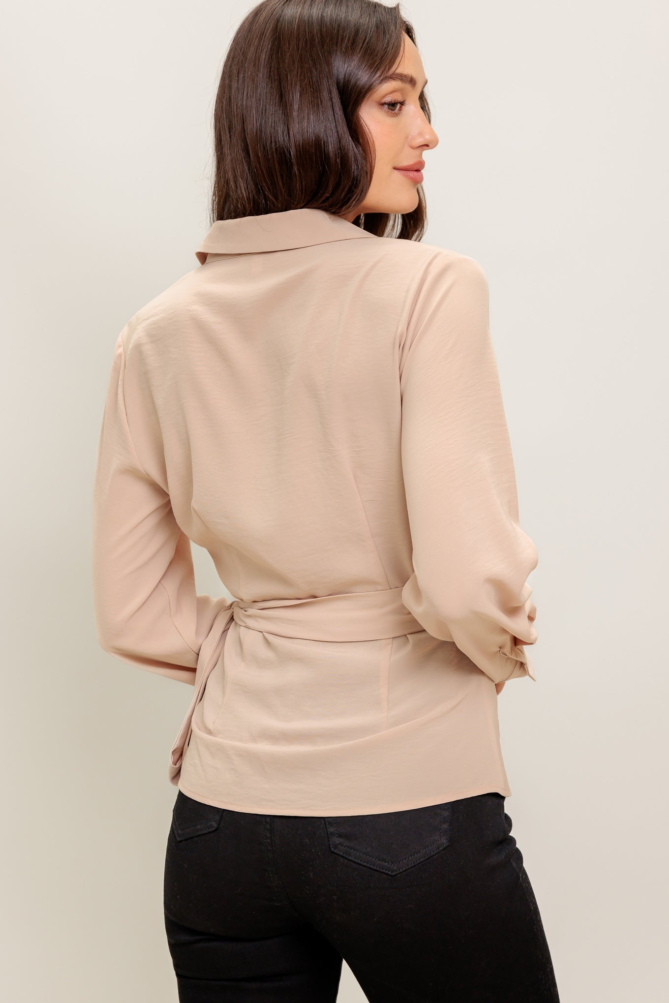 A solid woven top featuring collar, surplice neckline, long sleeve and true wrap