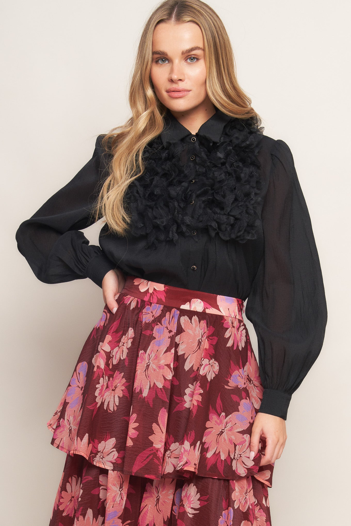 A solid woven top featuring shirt collar, button down, floral embellished front and long sleeve