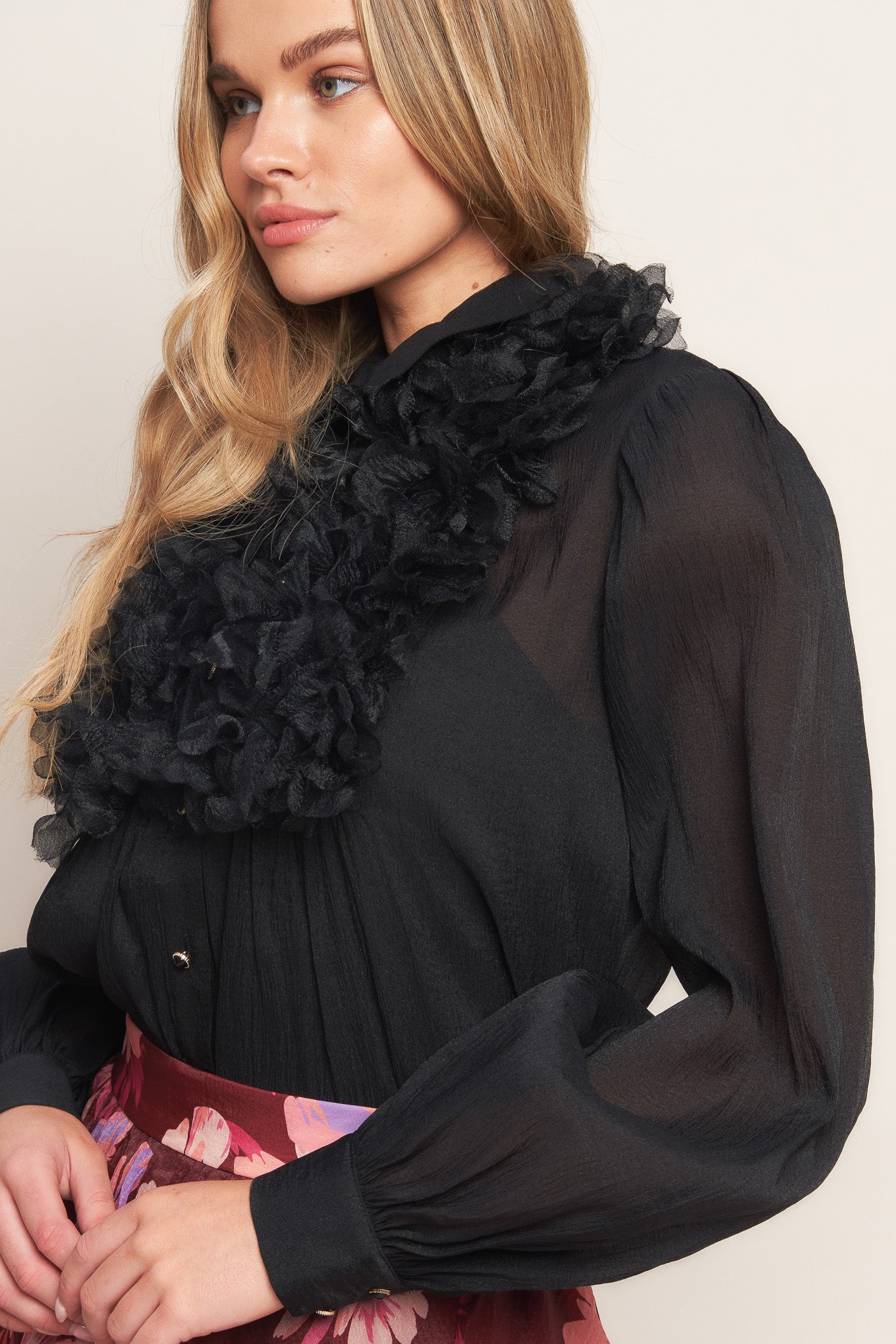 A solid woven top featuring shirt collar, button down, floral embellished front and long sleeve