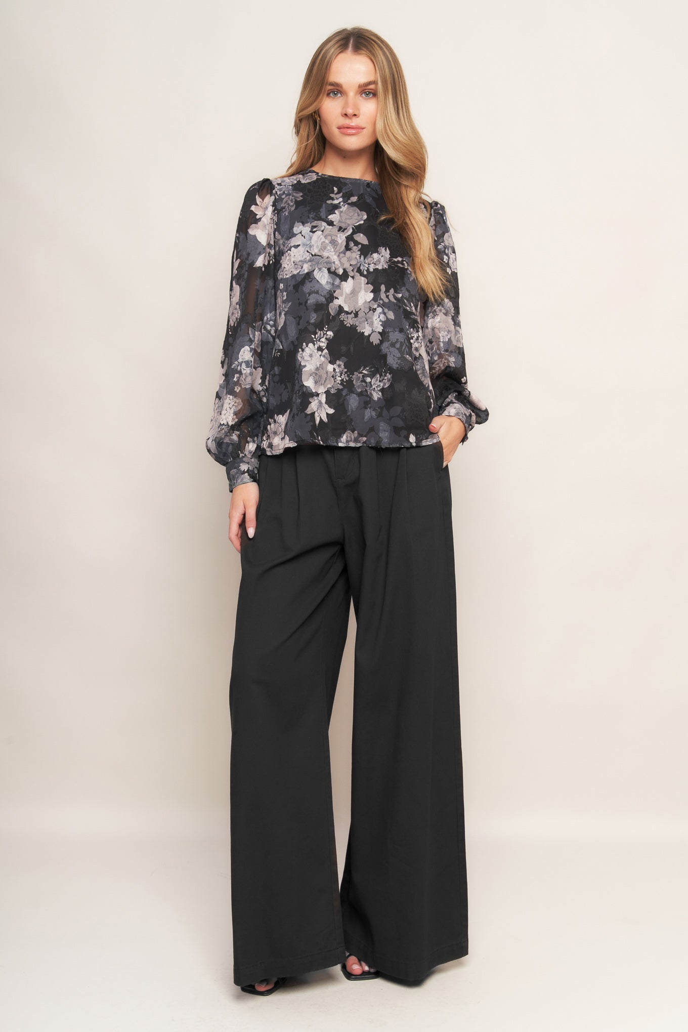 A printed woven top featuring round neckline, long sleeve and back bow tie detail