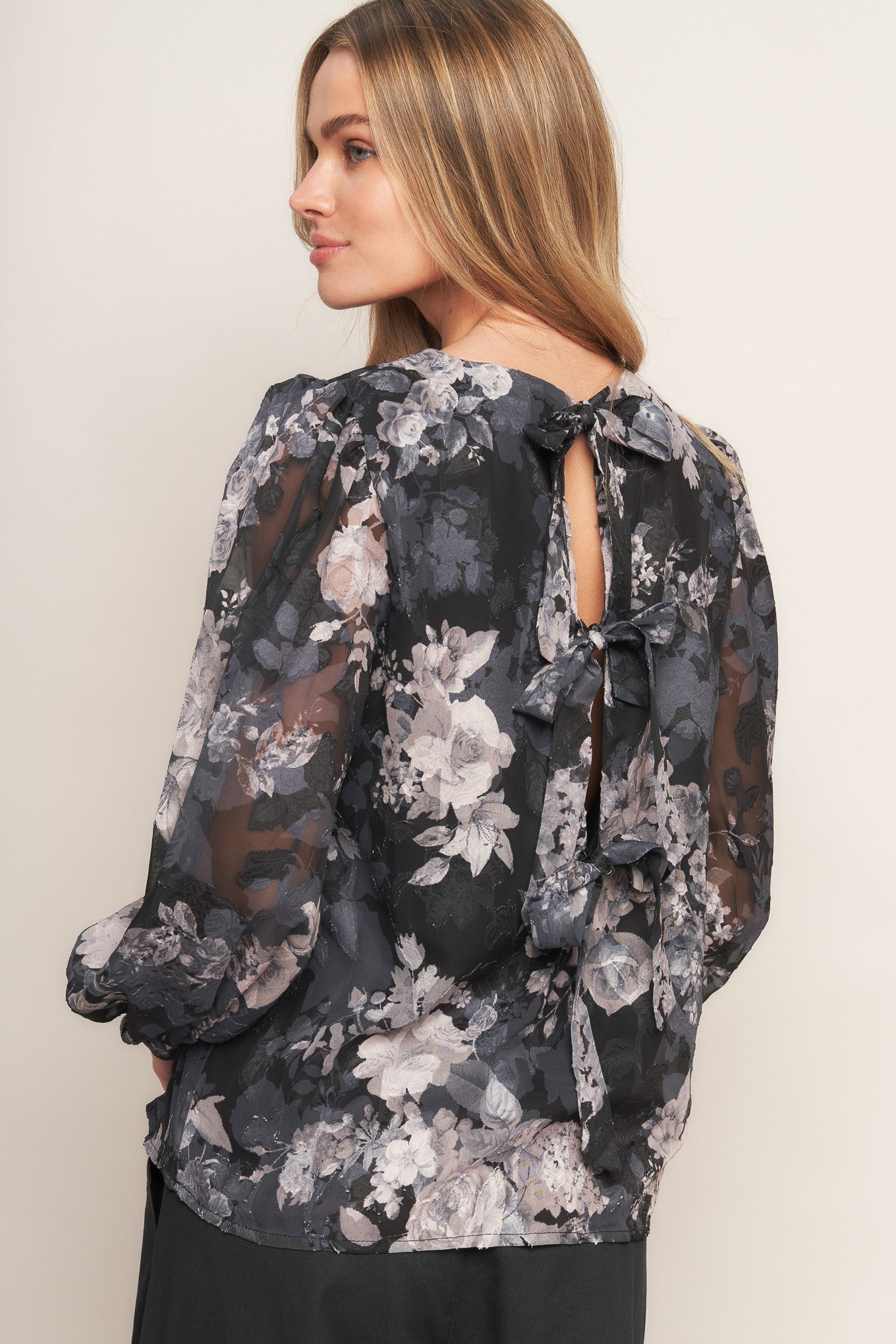 A printed woven top featuring round neckline, long sleeve and back bow tie detail