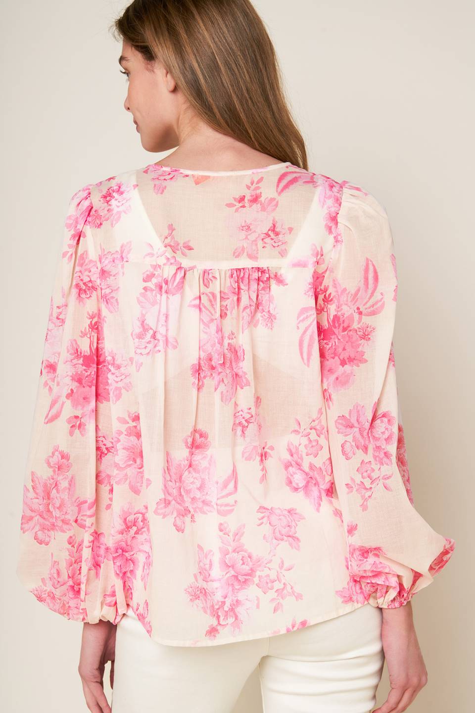 A printed woven peasant top featuring round neckline with tie/tassel, long sleeve and lace inset detail