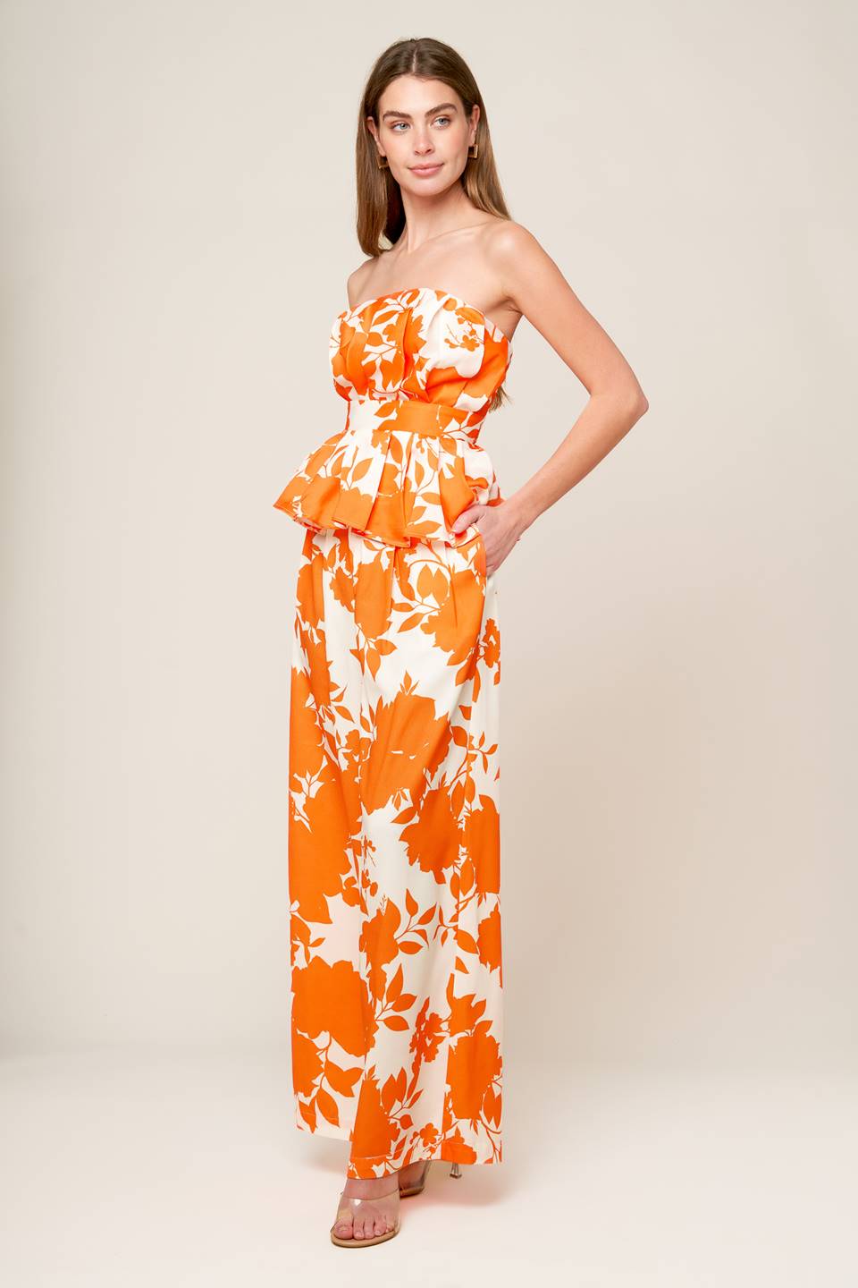 A white and orange, strapless, printed woven top featuring box pleats, peplum and smocked back bodice.