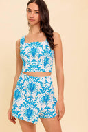A printed top and skort set. Top featuring square neckline, sleeveless and back zipper closure. Skort with side zipper closure
