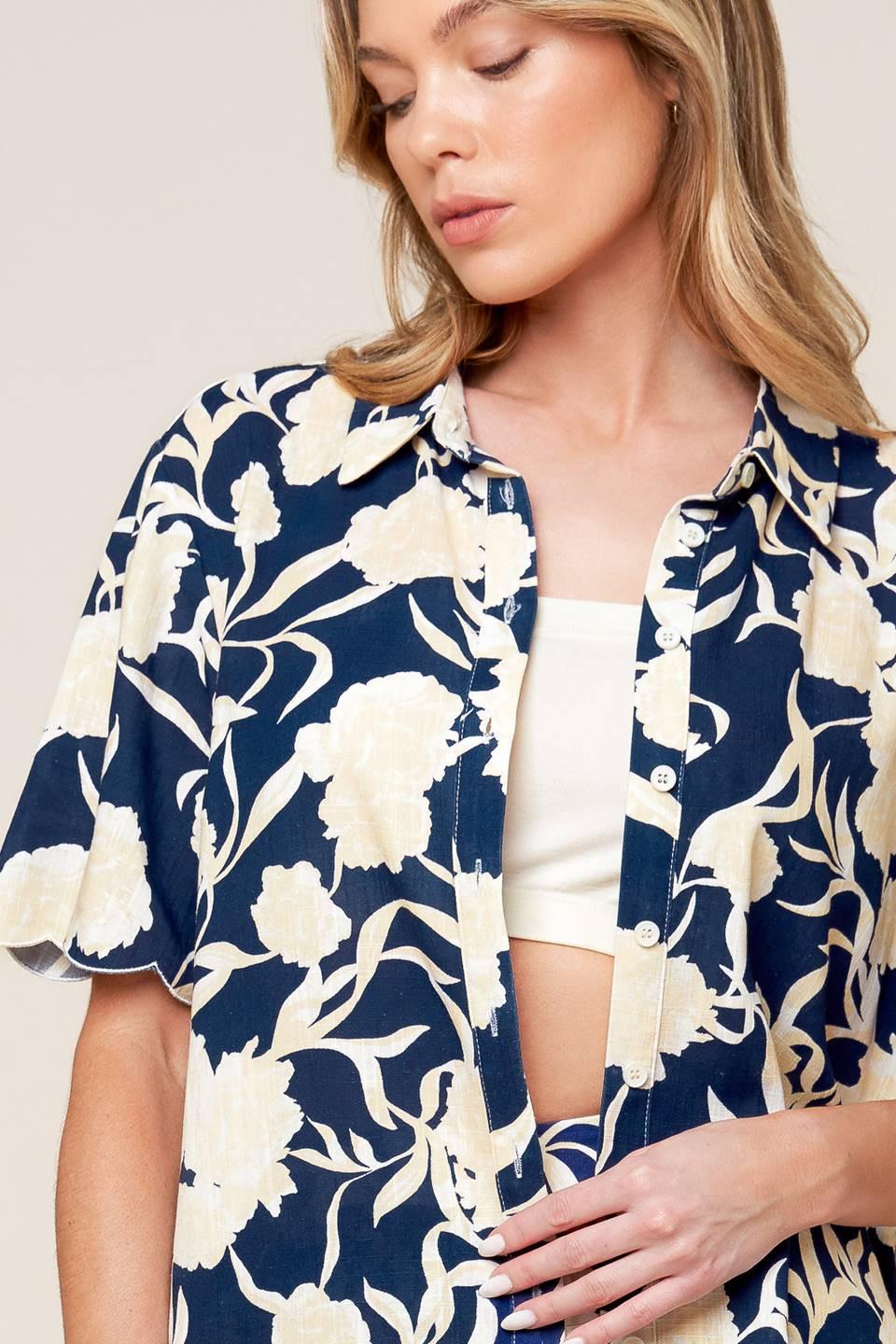 A printed woven top and shorts set. Top featuring collar, button down and short sleeve. Shorts with elasticized back waistband