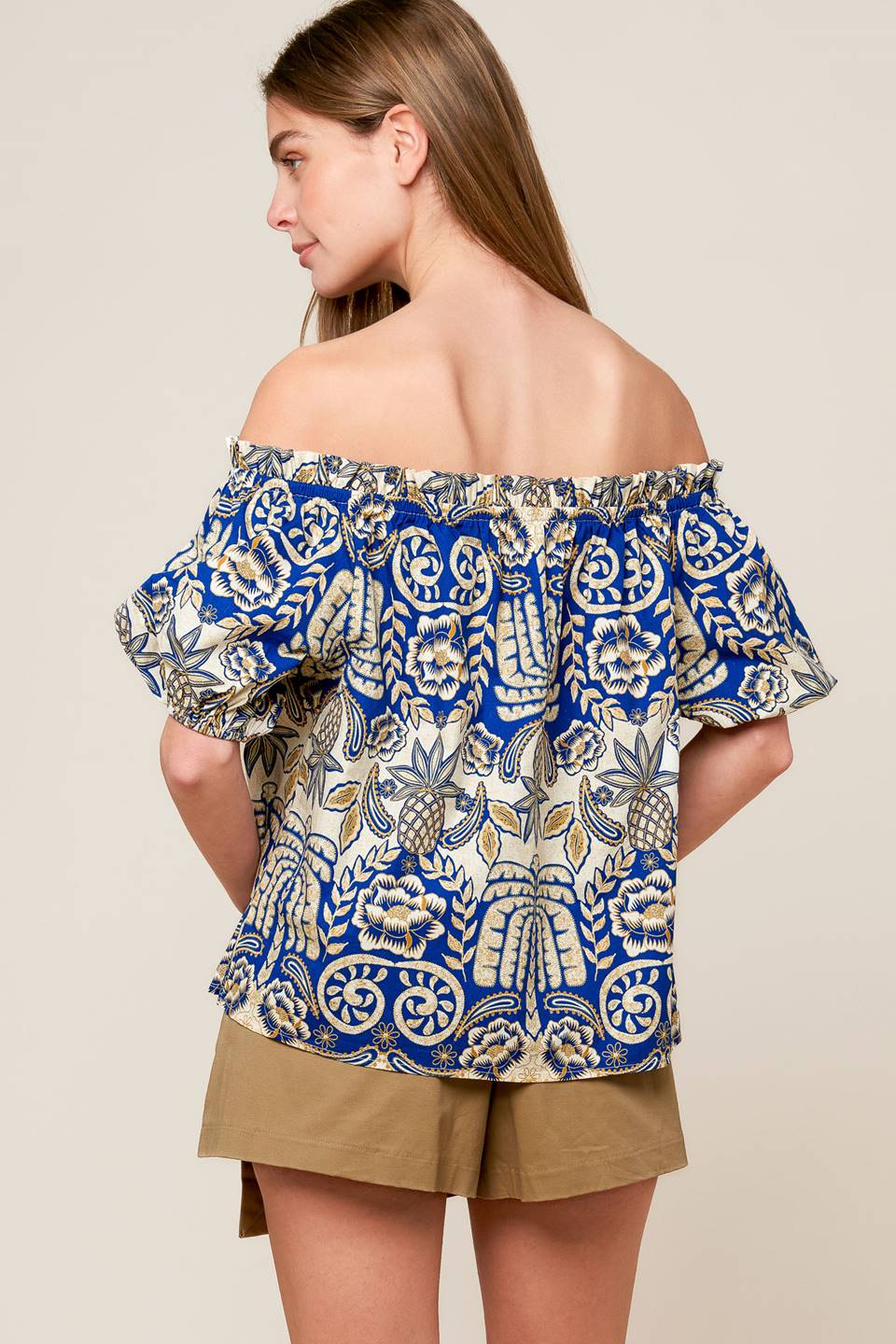 A printed woven on/off shoulder top with short puff sleeve.