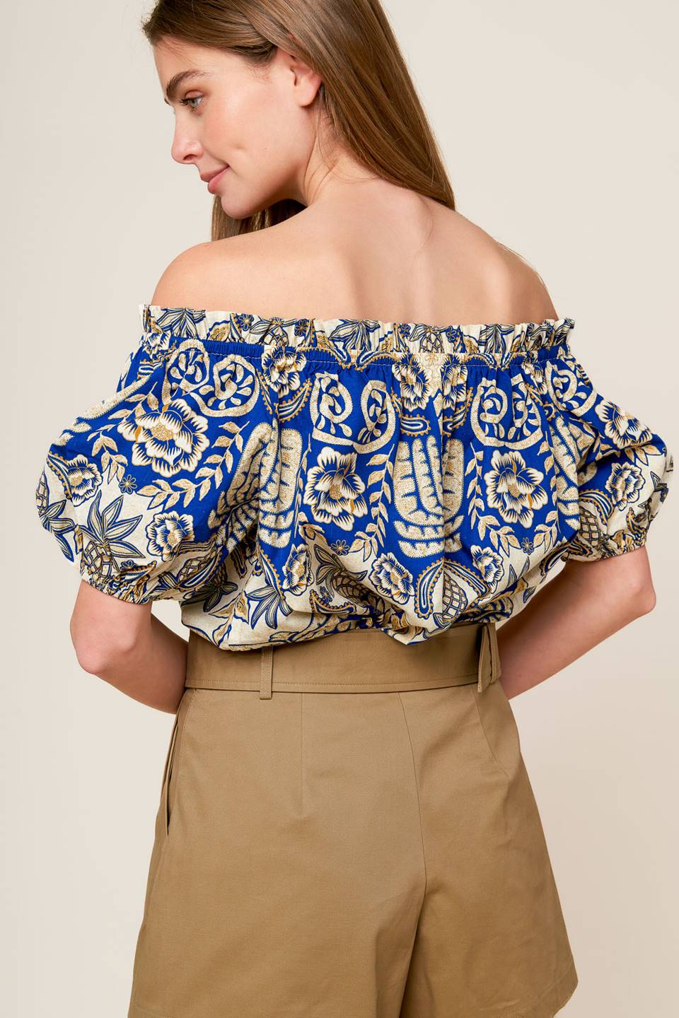 A printed woven on/off shoulder top with short puff sleeve.