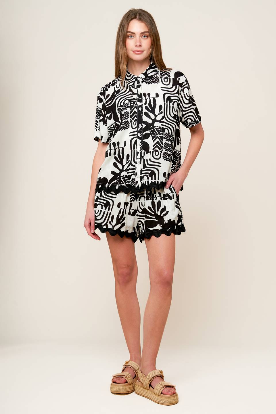 A printed woven top and shorts set. Top featuring collar, short sleeves, button down and ric rac ribbon trimmed hem. Short featuring elasticized waistband with tie and ric rac ribbon trimmed hem.