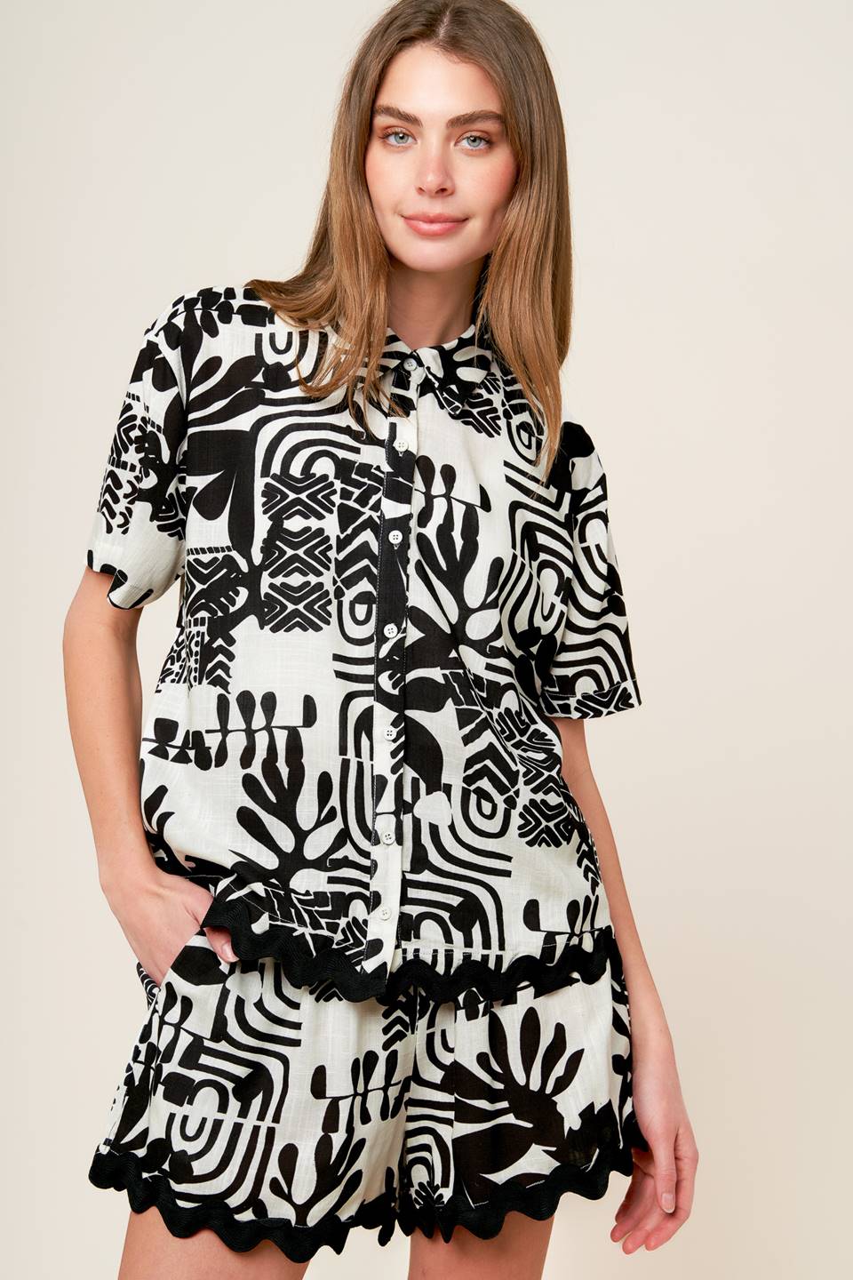 A printed woven top and shorts set. Top featuring collar, short sleeves, button down and ric rac ribbon trimmed hem. Short featuring elasticized waistband with tie and ric rac ribbon trimmed hem.