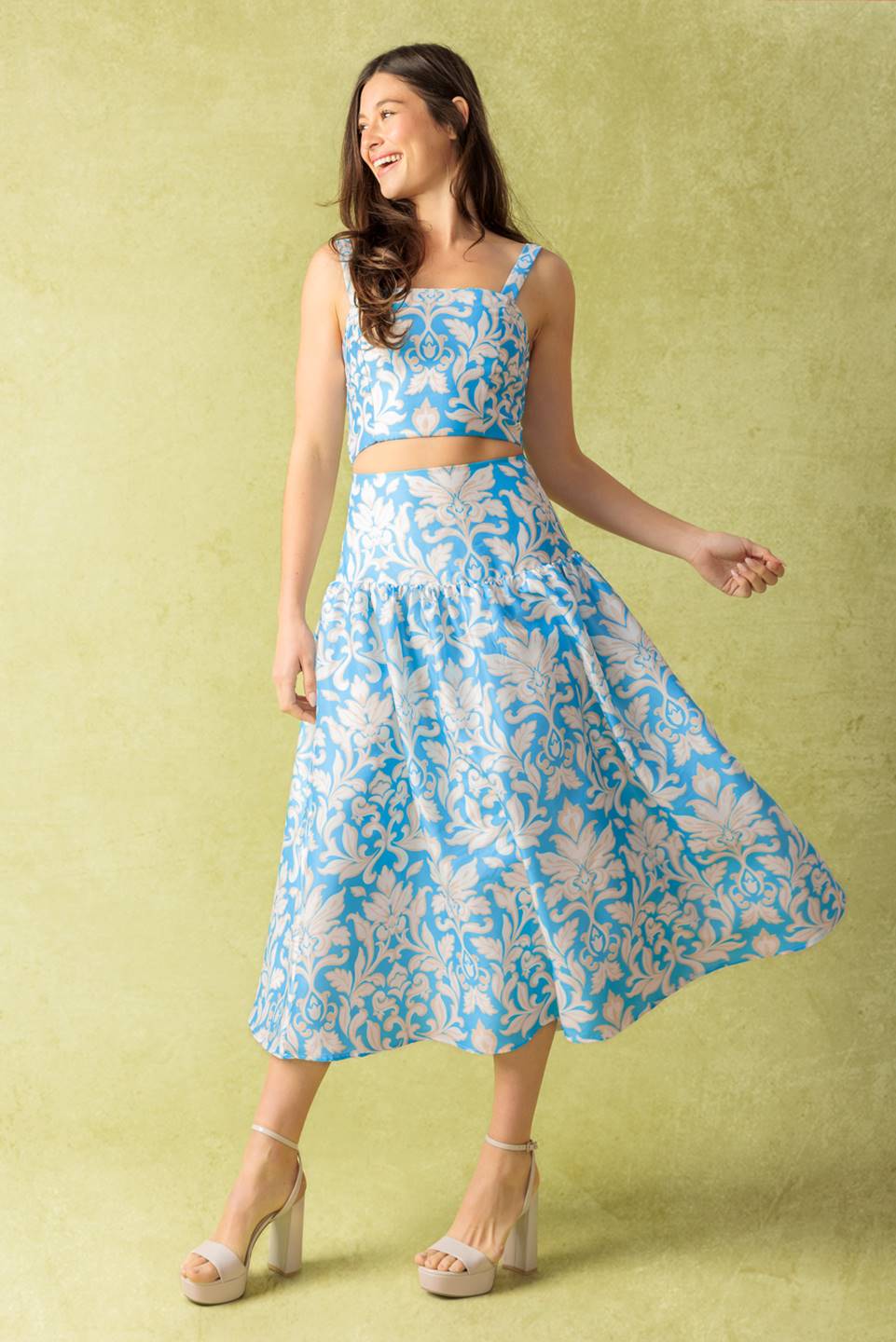 A printed woven top and skirt set. Top featuring a straight neckline, shoulder straps, and smocked back bodice. Full skirt with back zipper closure