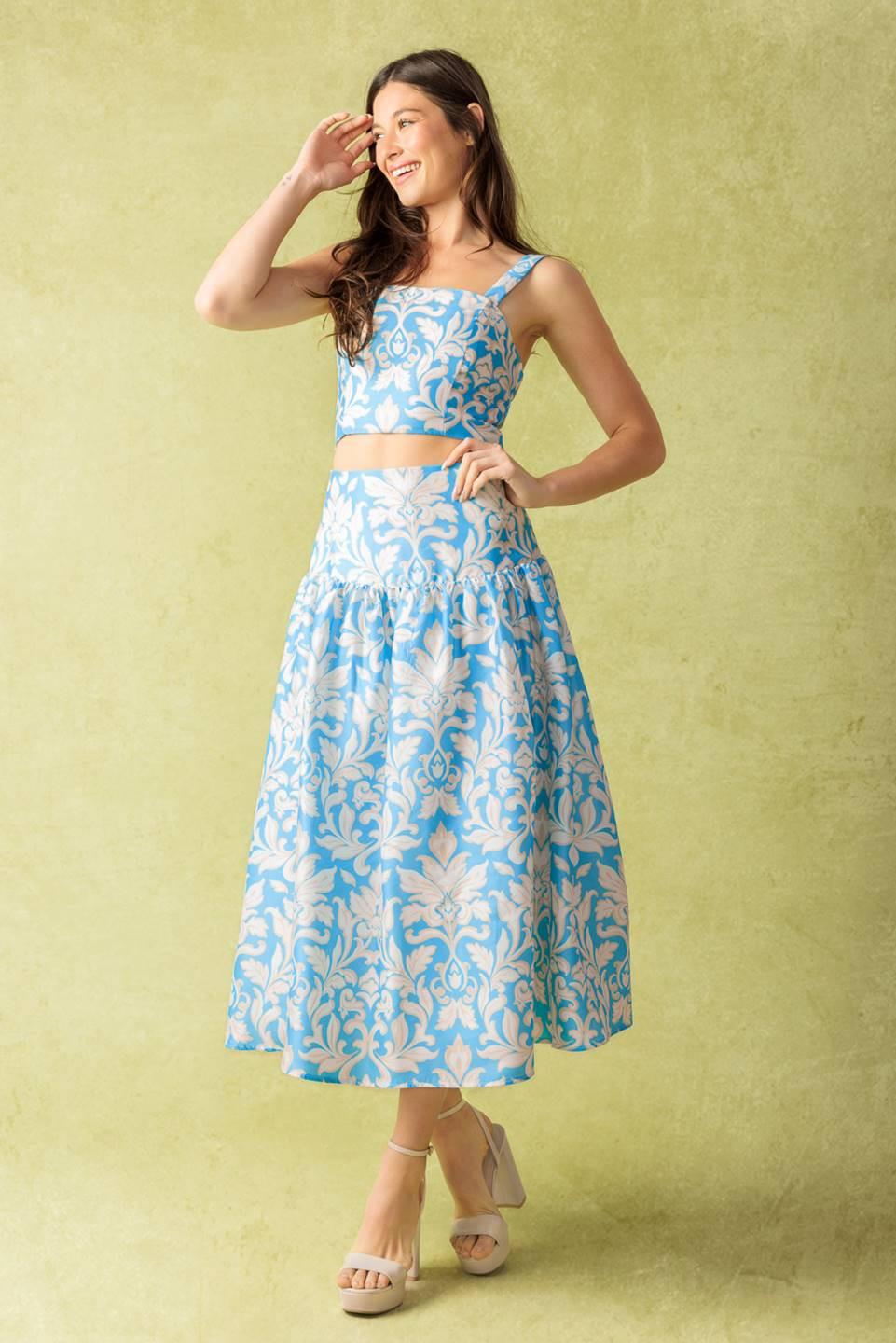 A printed woven top and skirt set. Top featuring a straight neckline, shoulder straps, and smocked back bodice. Full skirt with back zipper closure