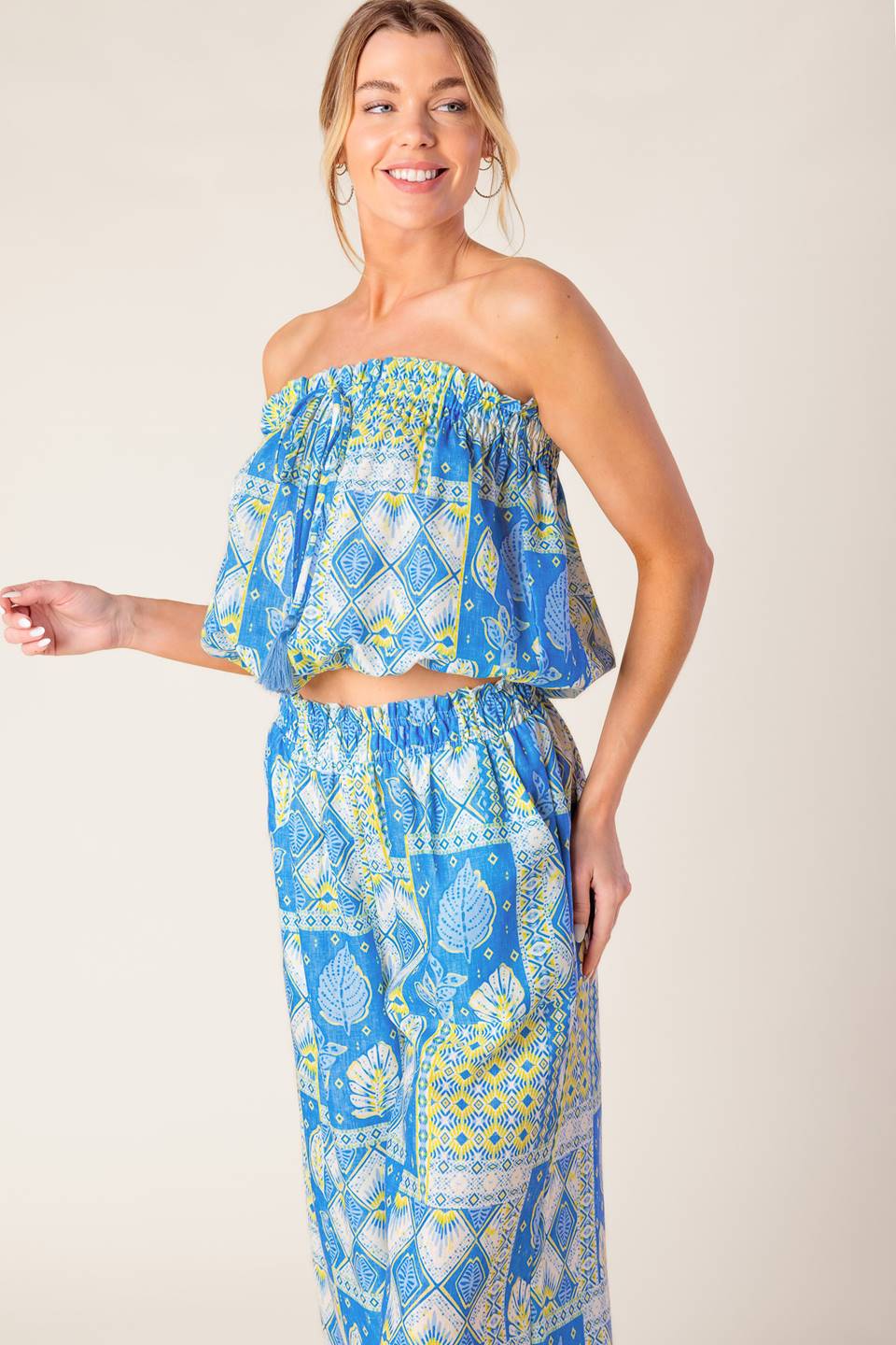 A printed woven top and pant set. Top featuring strapless with elasticized opening and waist. Pant featuring elasticized waist and wide leg