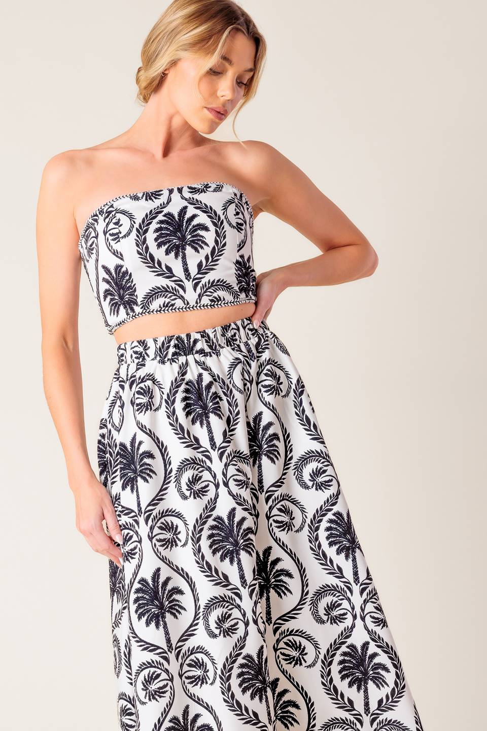 A printed woven top and skirt set. Top featuring bandeau top with trim and smocked back bodice. Midi skirt with elasticized waist.