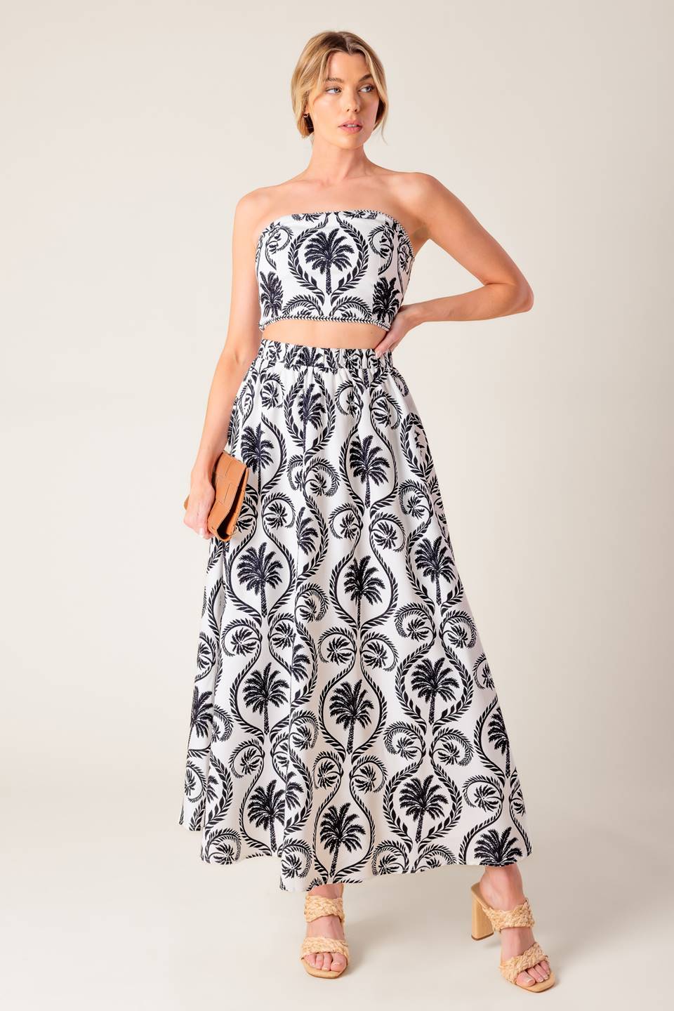 A printed woven top and skirt set. Top featuring bandeau top with trim and smocked back bodice. Midi skirt with elasticized waist.