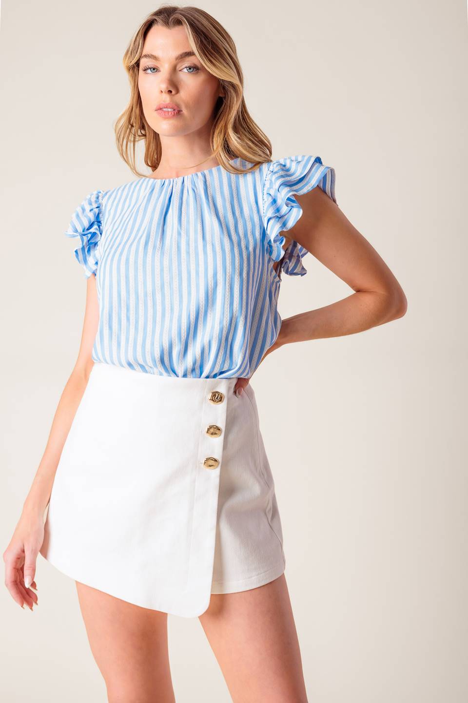 A blue and white textured woven top featuring round neckline, double layer ruffled sleeve and back neck button closure.