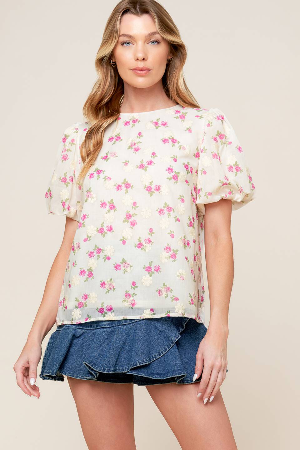 A textured floral printed woven top featuring round neckline, short balloon sleeves and back neck tie closure.