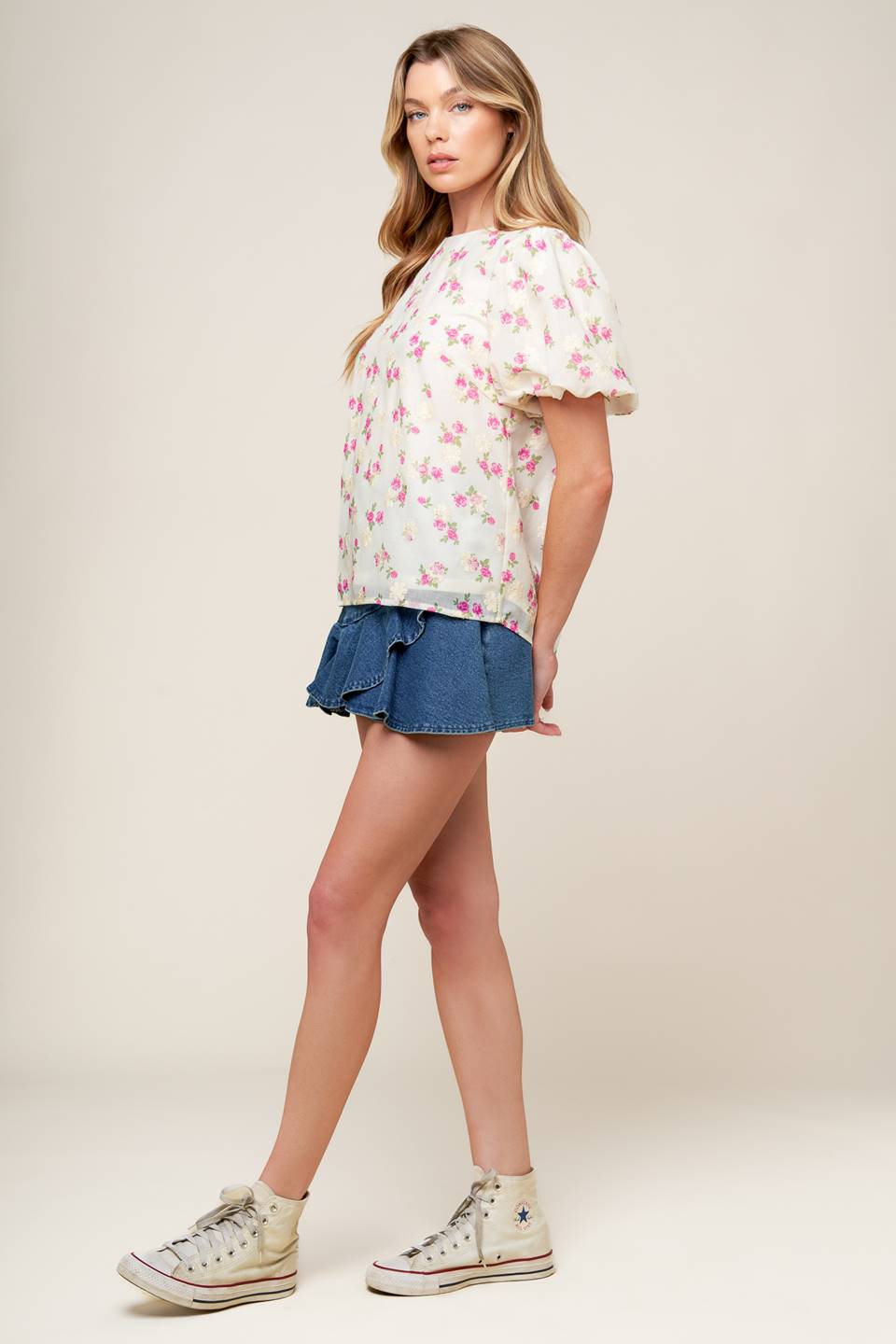 A textured floral printed woven top featuring round neckline, short balloon sleeves and back neck tie closure.