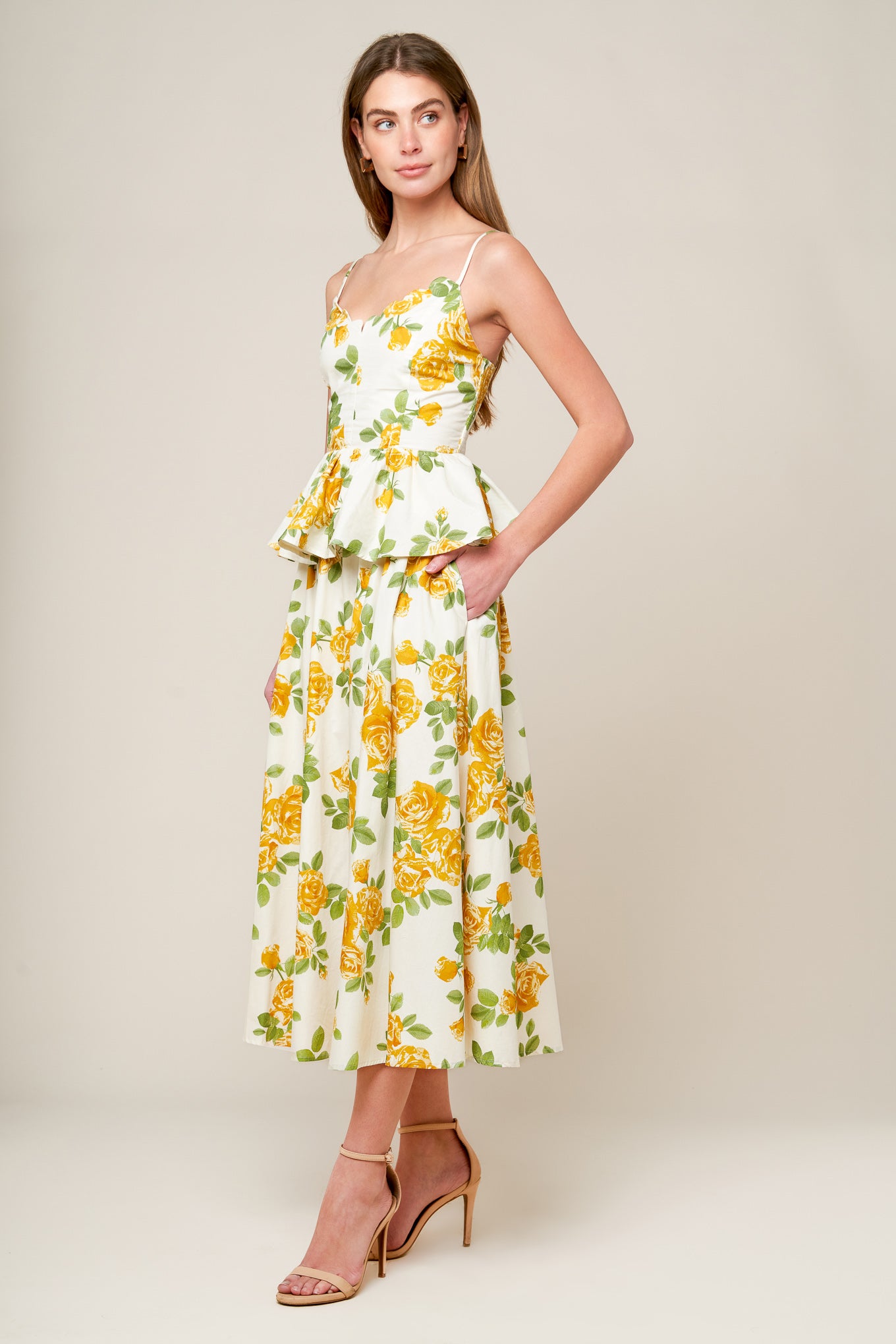 A printed woven top featuring scalloped V neckline, straps, peplum, full skirt and smocked back bodice