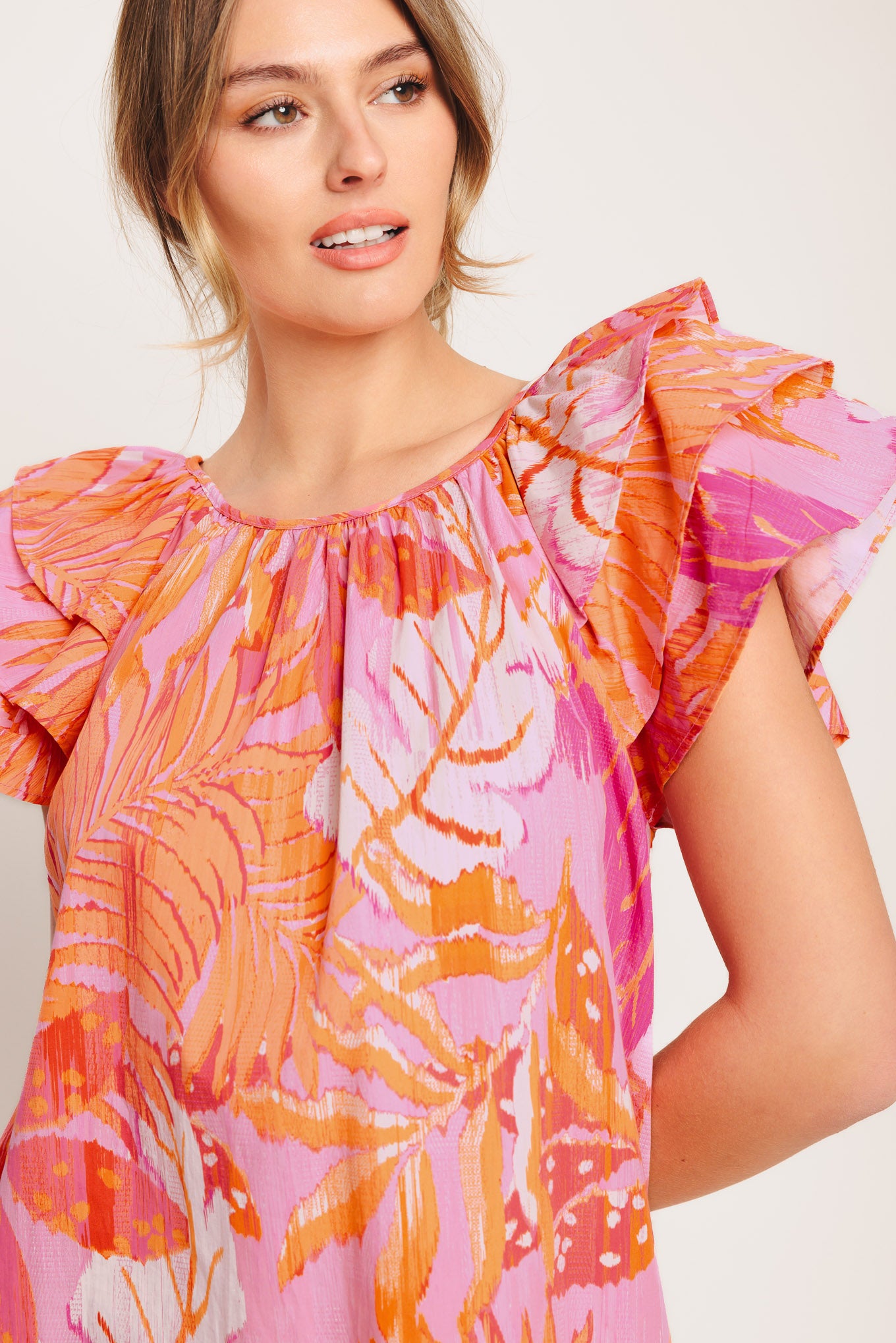 A printed woven top featuring round neckline, layered flutter sleeve and back neck button closure

Details:

Self : 100% Cotton

Size &amp; Fit

- Model is 5`8" And Wearing Size Small
- Measurements Taken From Size Small
- Approx. Length: 26"