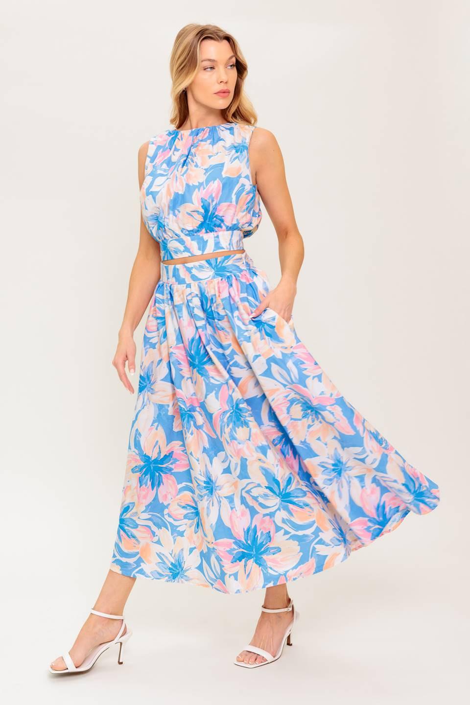 A printed woven top and skirt set. Top featuring side neckline, shirring, sleeveless and back tie and button closure. Full skirt with side zipper closure