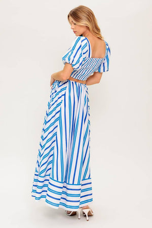 A striped woven top and skirt set. Top featuring sweetheart neckline with center bow and cut out, short puff sleeve and smocked back bodice. Circle skirt featuring side tie and zipper closure