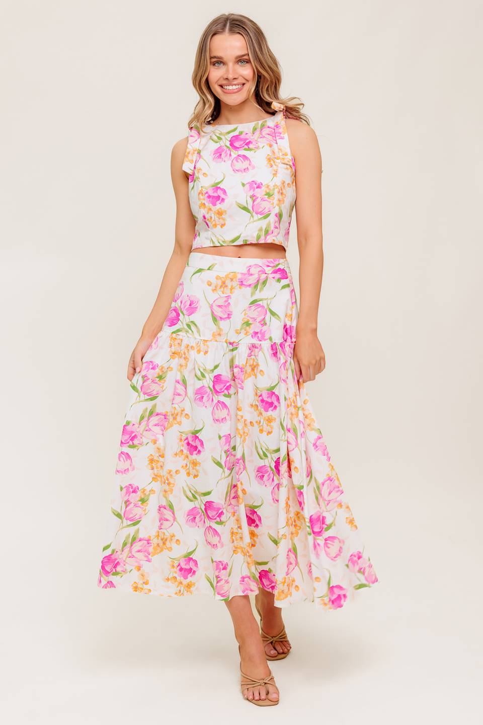 A printed woven top and skirt set. Top featuring crop length, round neckline, sleeveless, shoulder tie and back zipper closure. Midi skirt with side zipper closure.