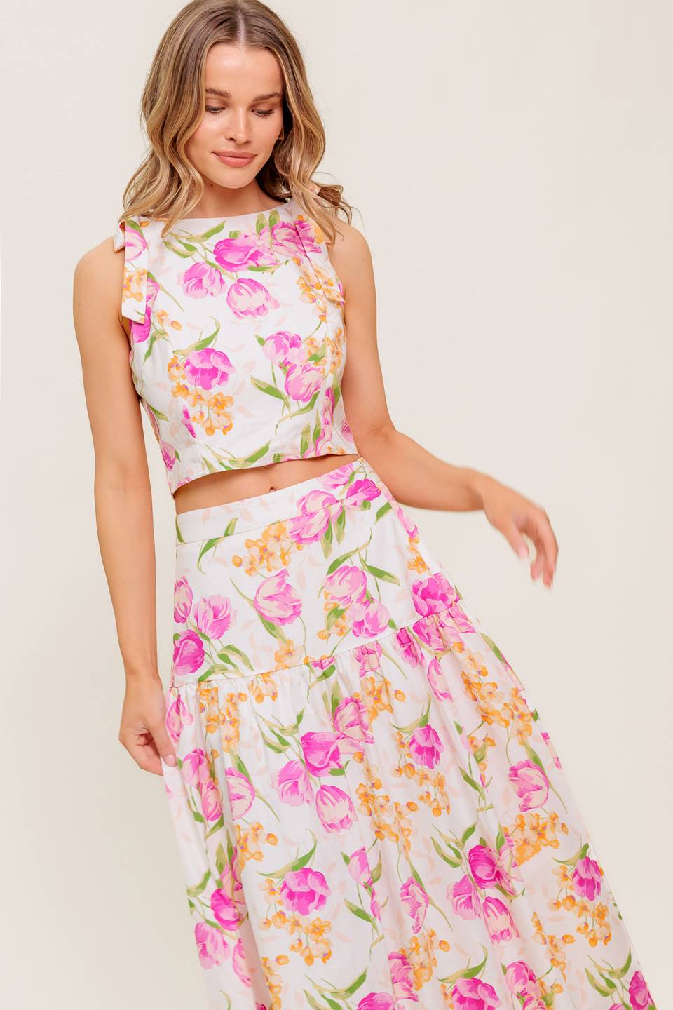 A printed woven top and skirt set. Top featuring crop length, round neckline, sleeveless, shoulder tie and back zipper closure. Midi skirt with side zipper closure.