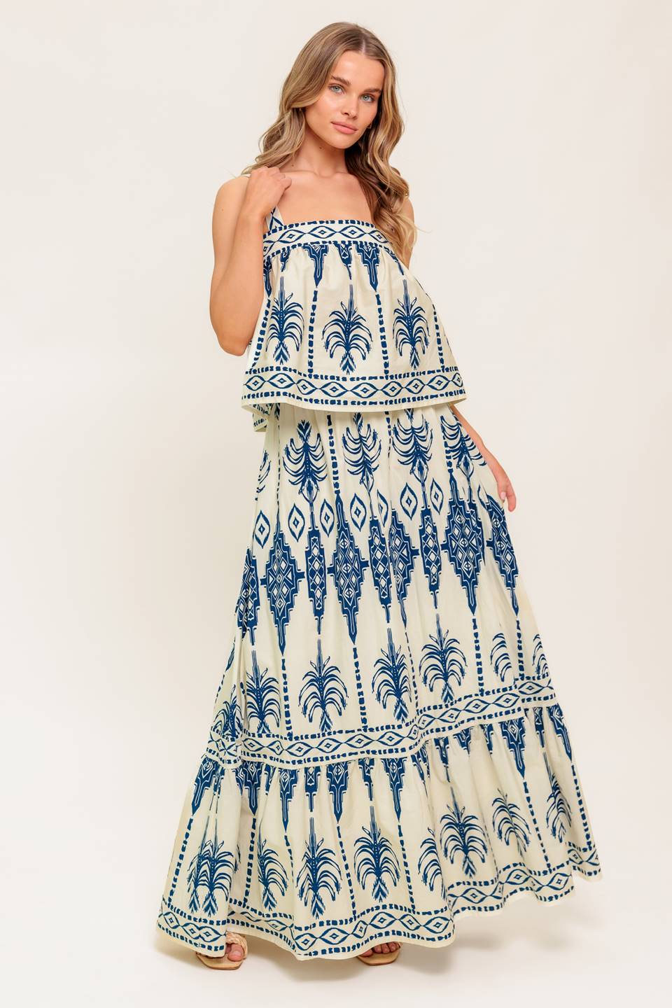 A printed woven top and skirt set. Top featuring straight neckline, straps and smocked back band. Ankle skirt with ruffled hem and side zipper closure.