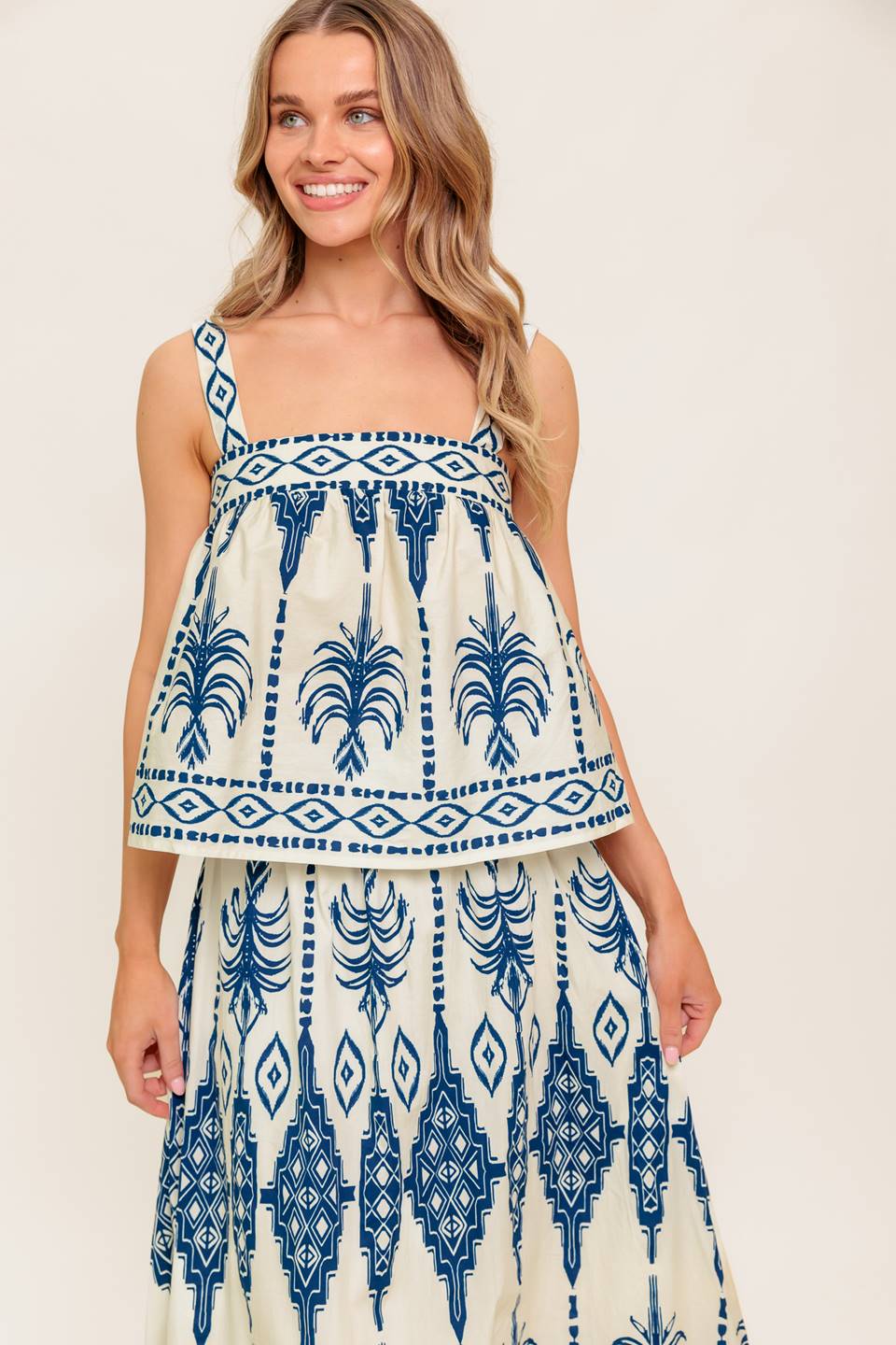 A printed woven top and skirt set. Top featuring straight neckline, straps and smocked back band. Ankle skirt with ruffled hem and side zipper closure.