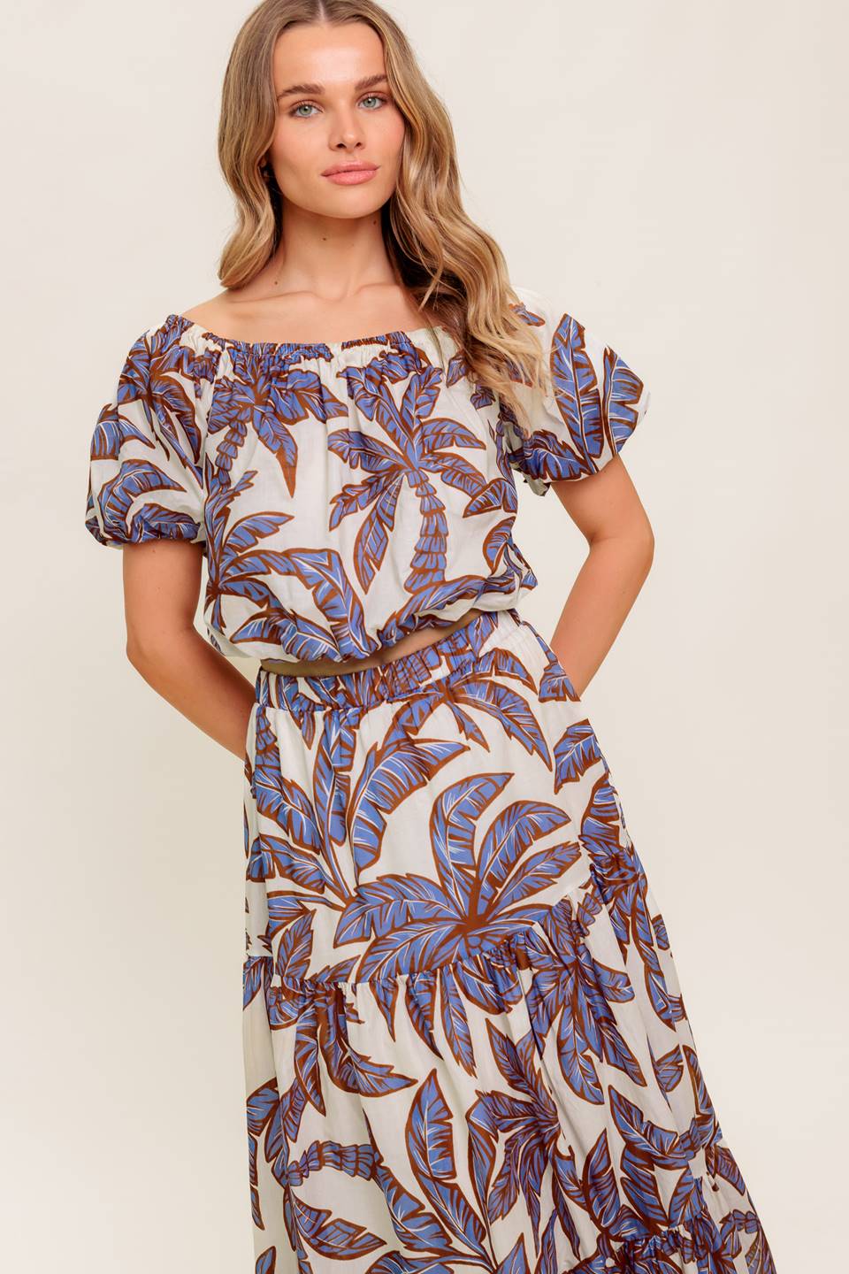 A printed woven top featuring on/off shoulder neckline, short puff sleeve and elasticized waist.