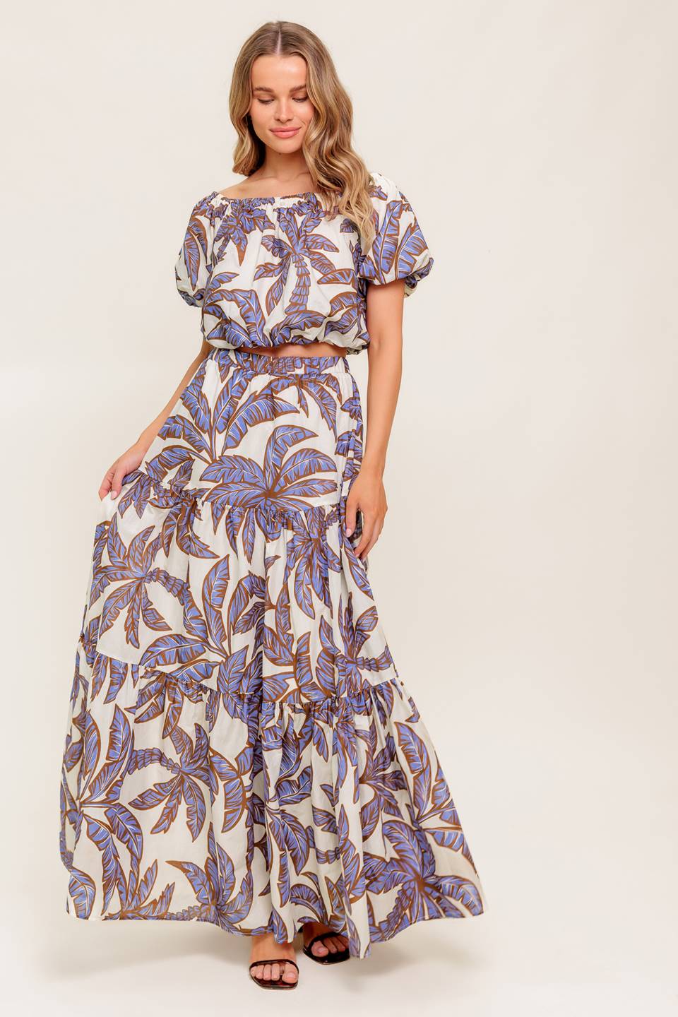 A printed woven top featuring on/off shoulder neckline, short puff sleeve and elasticized waist.