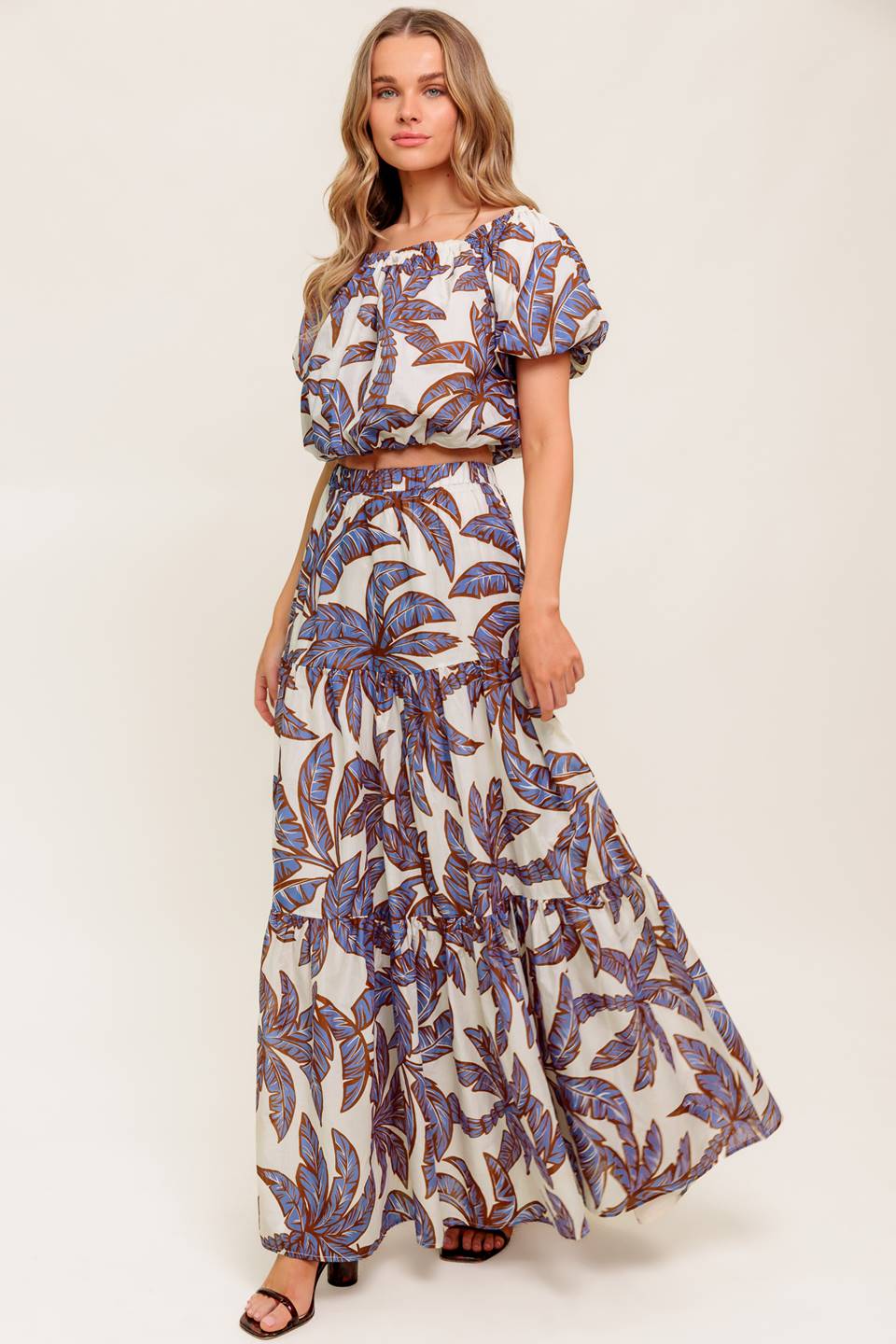 A printed woven top featuring on/off shoulder neckline, short puff sleeve and elasticized waist.