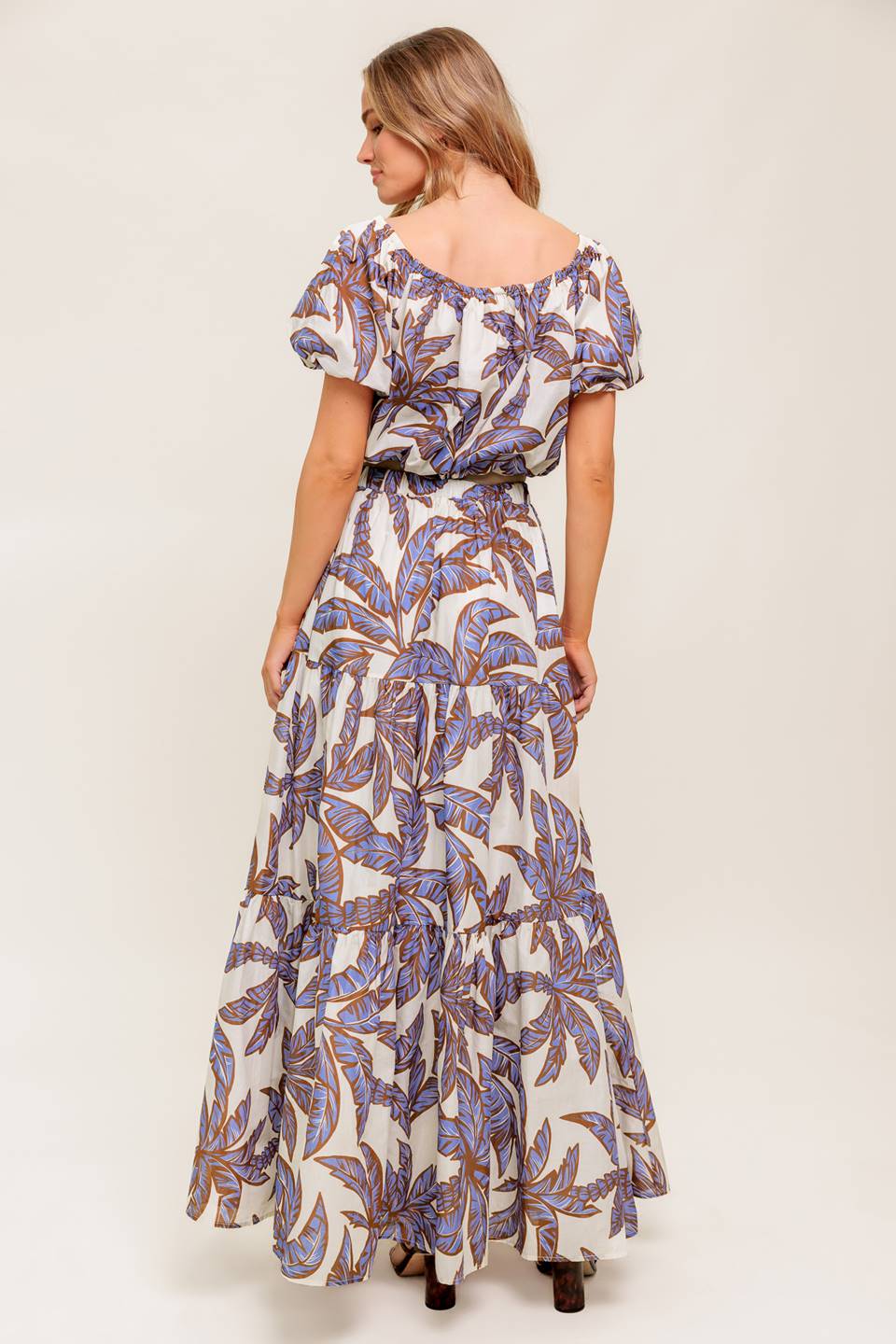A printed woven top featuring on/off shoulder neckline, short puff sleeve and elasticized waist.