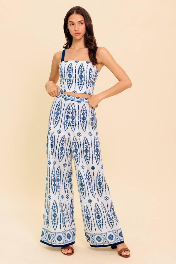 A printed woven top and pant set. Crop top featuring straight neckline, straps and smocked back bodice. Pant featuring wide leg and side zipper closure