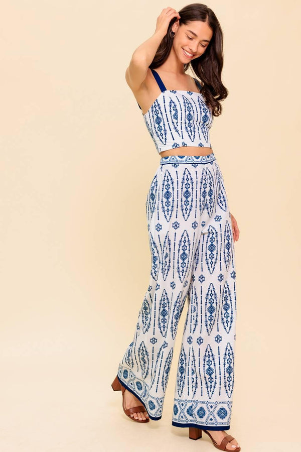 A printed woven top and pant set. Crop top featuring straight neckline, straps and smocked back bodice. Pant featuring wide leg and side zipper closure