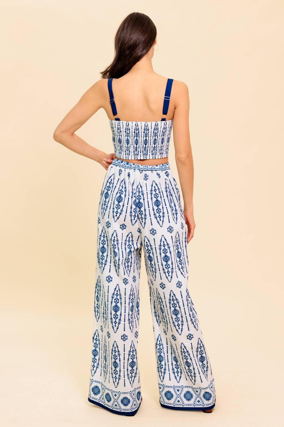 A printed woven top and pant set. Crop top featuring straight neckline, straps and smocked back bodice. Pant featuring wide leg and side zipper closure