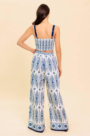 A printed woven top and pant set. Crop top featuring straight neckline, straps and smocked back bodice. Pant featuring wide leg and side zipper closure