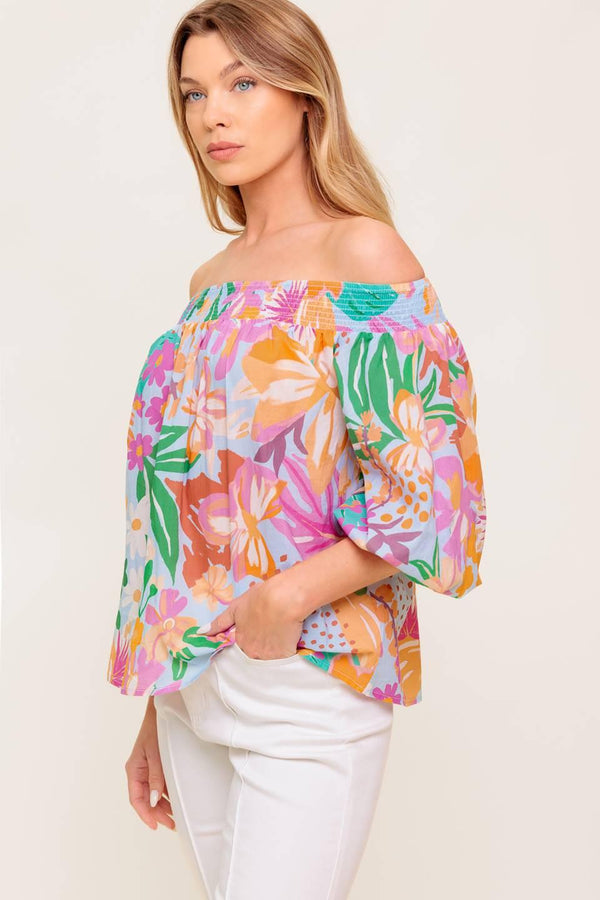 A printed woven top with off shoulder neckline.