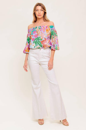 A printed woven top with off shoulder neckline.