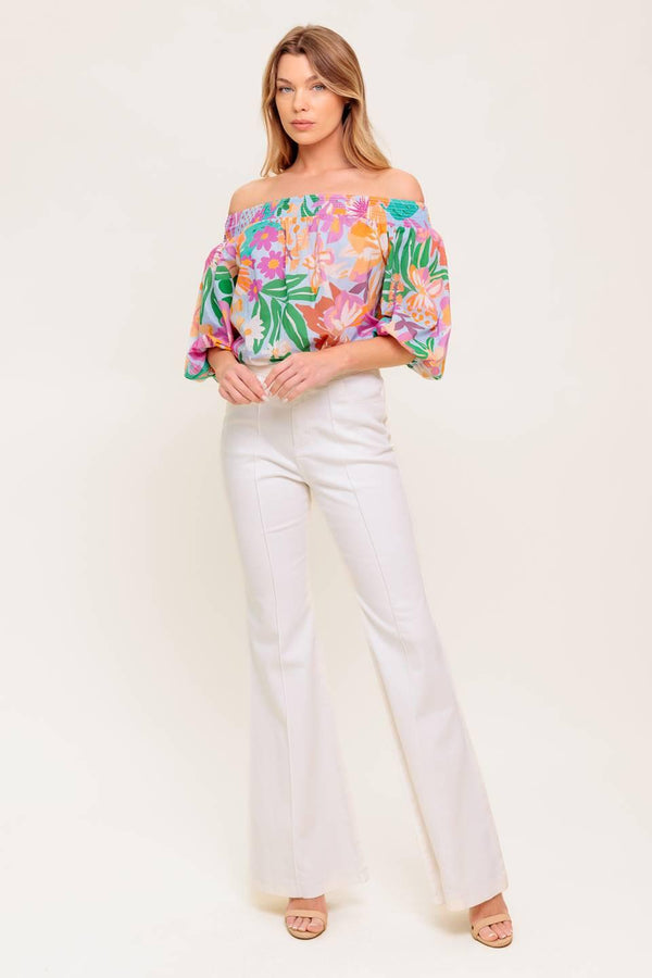 A printed woven top with off shoulder neckline.