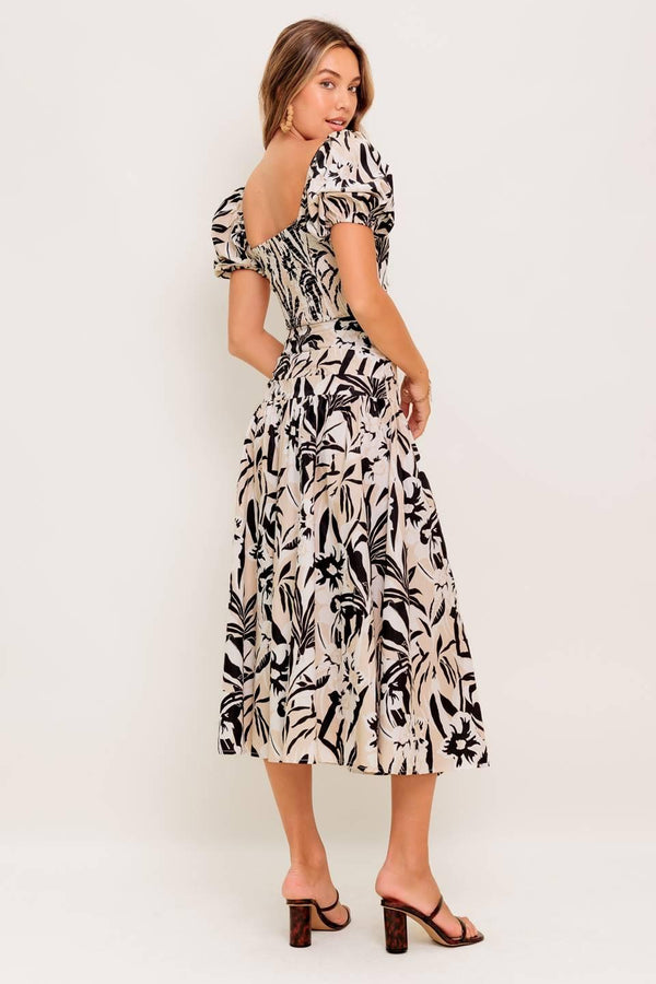 A printed woven top and skirt set featuring square neckline crop top with short puff sleeve and smocked back bodice. Matching skirt with side zipper closure