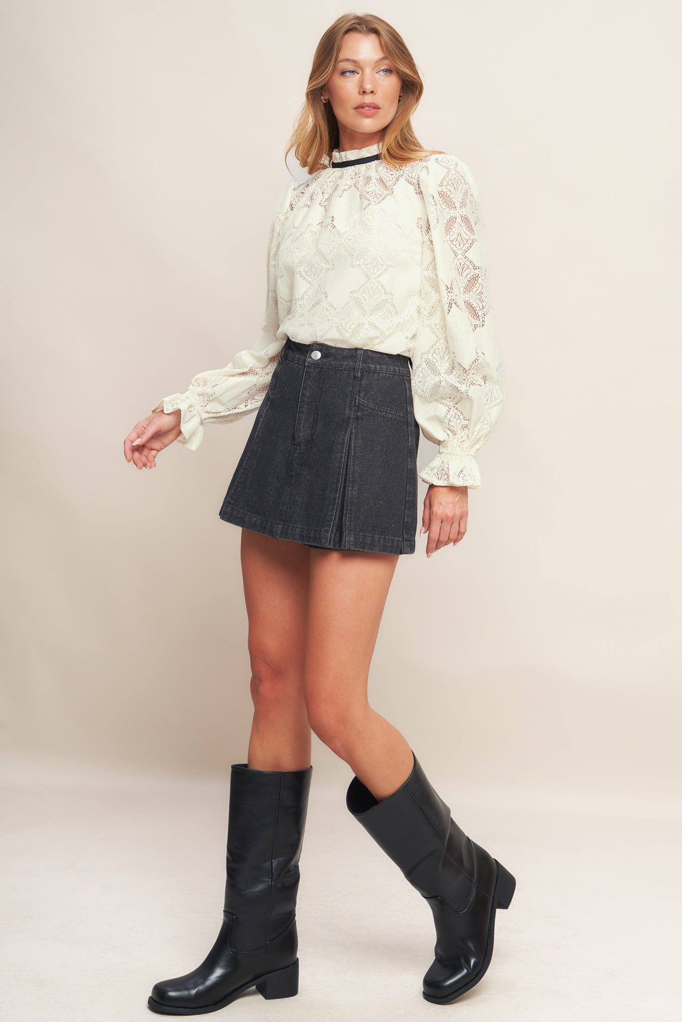 A woven lace top featuring ruffled high neckline with contrasting band, long sleeve with ruffled cuff, cami and back neck tie closure
