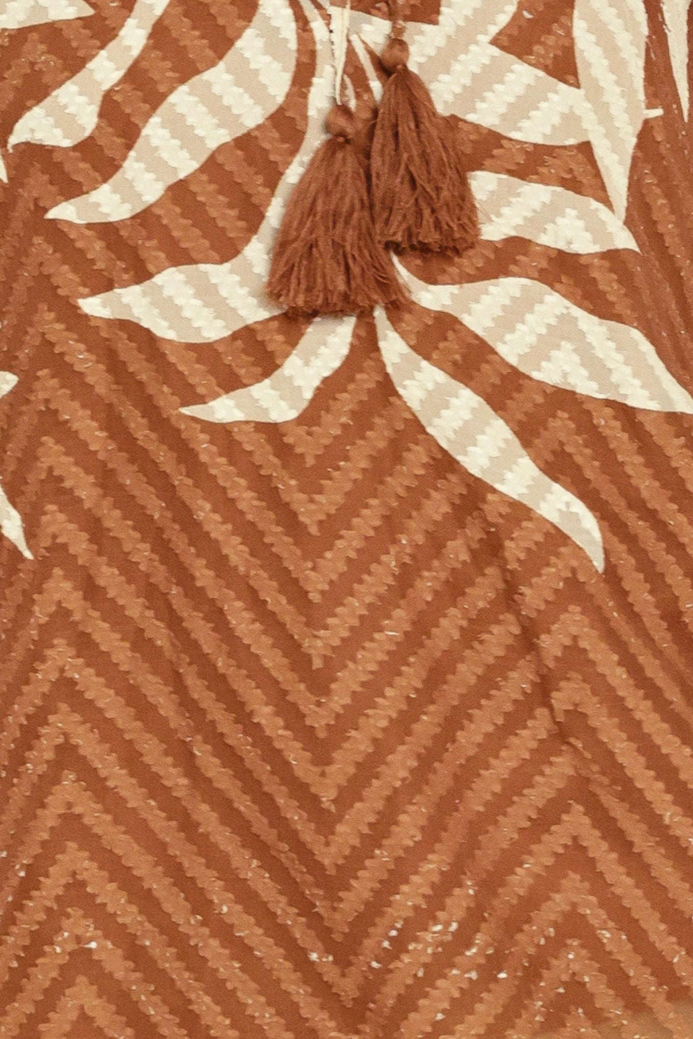 Woman wearing a long sleeve brown and beige leaf patterned blouse | Flying Tomato